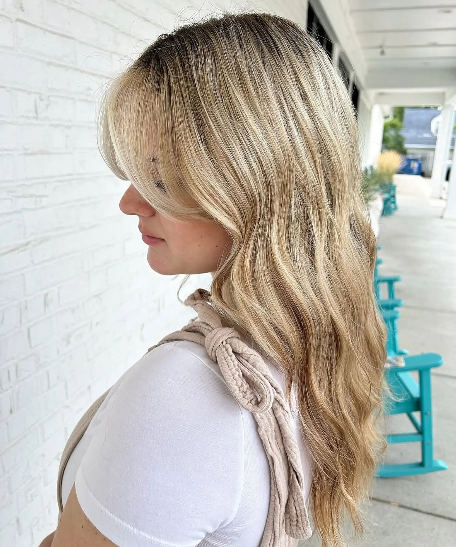 Long hair featuring dimensional blonde highlights and soft curtain bangs styled in gentle waves. 1