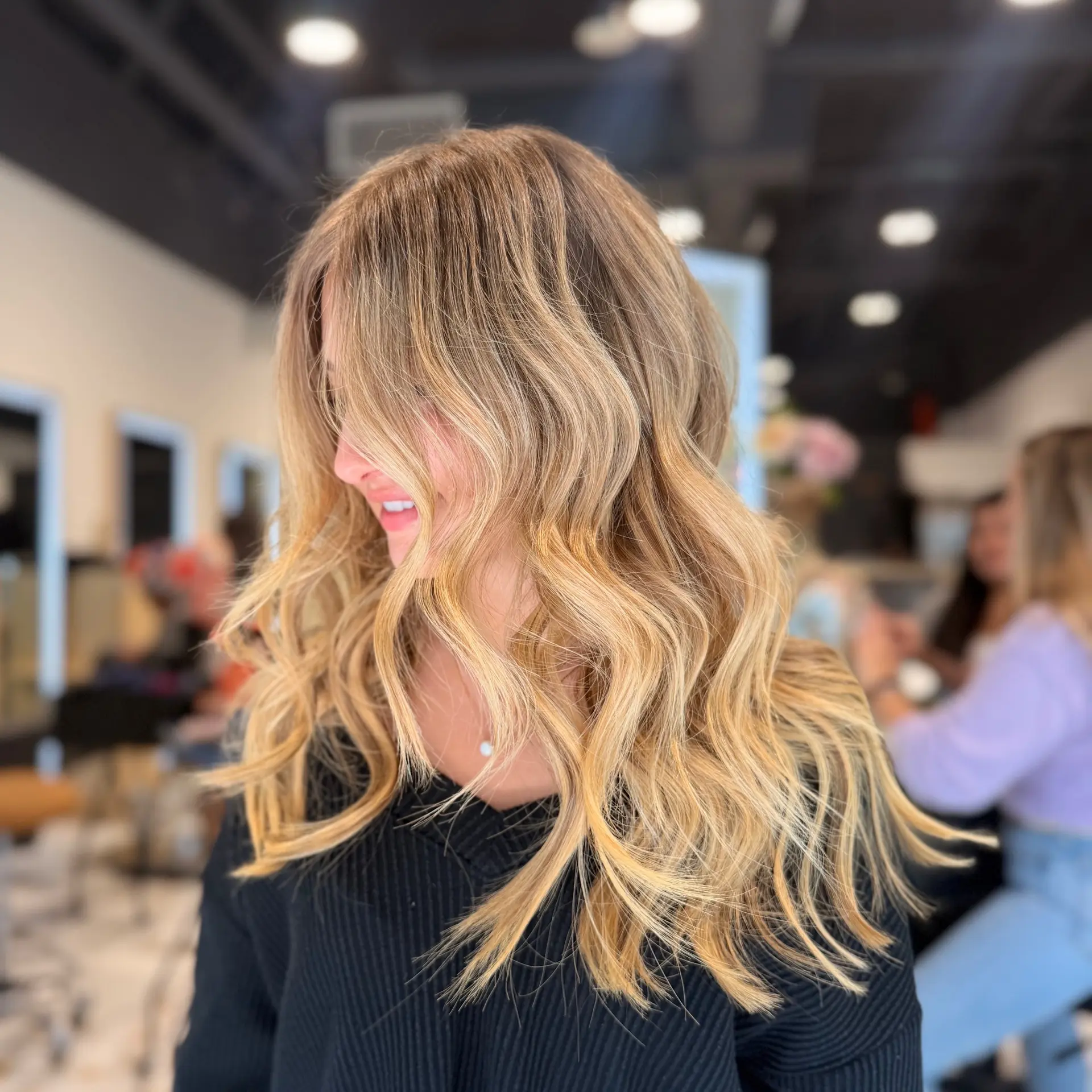 Long honey blonde hair styled with soft, voluminous beach waves. 1