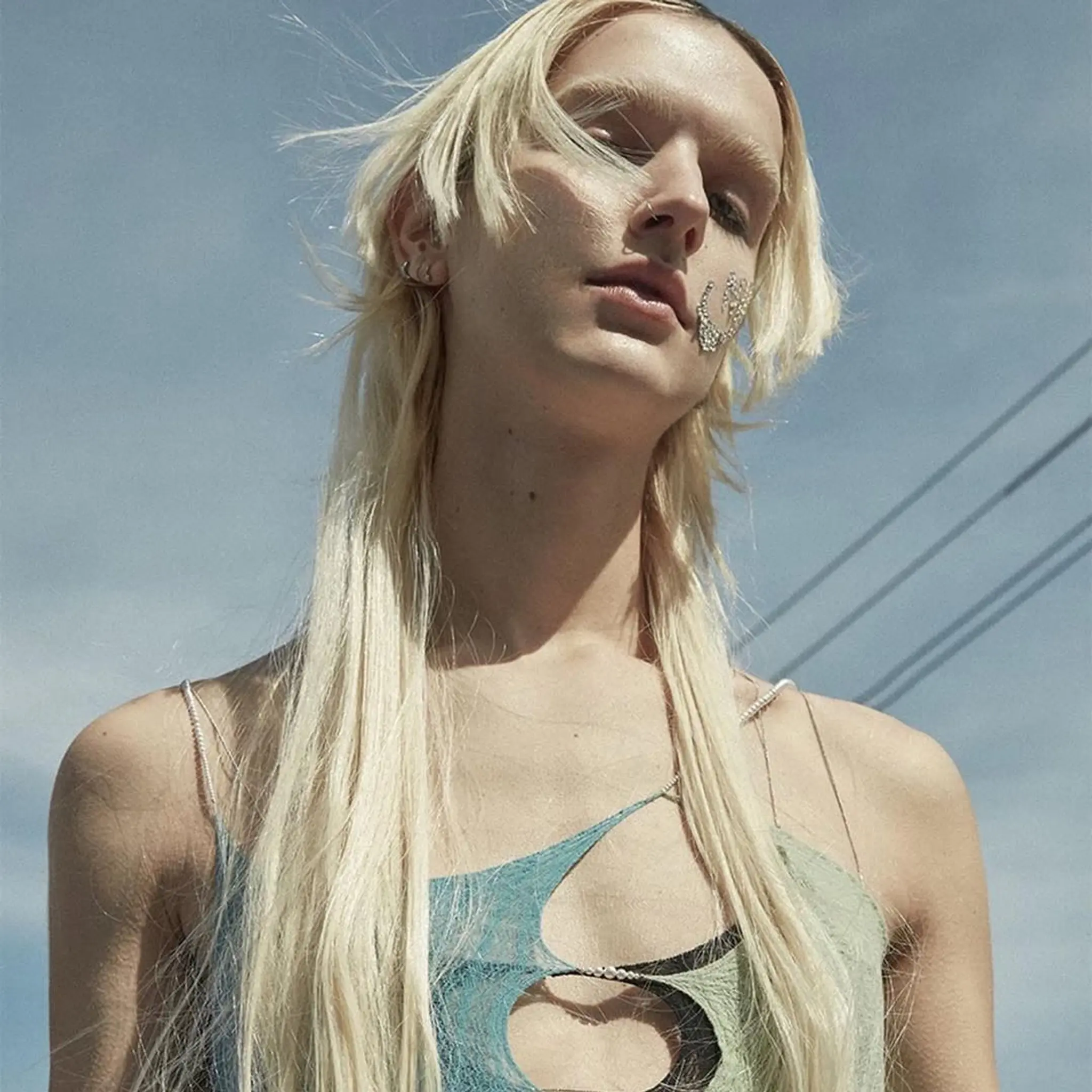 Very long, straight platinum blonde hair with wispy layers and a center part.