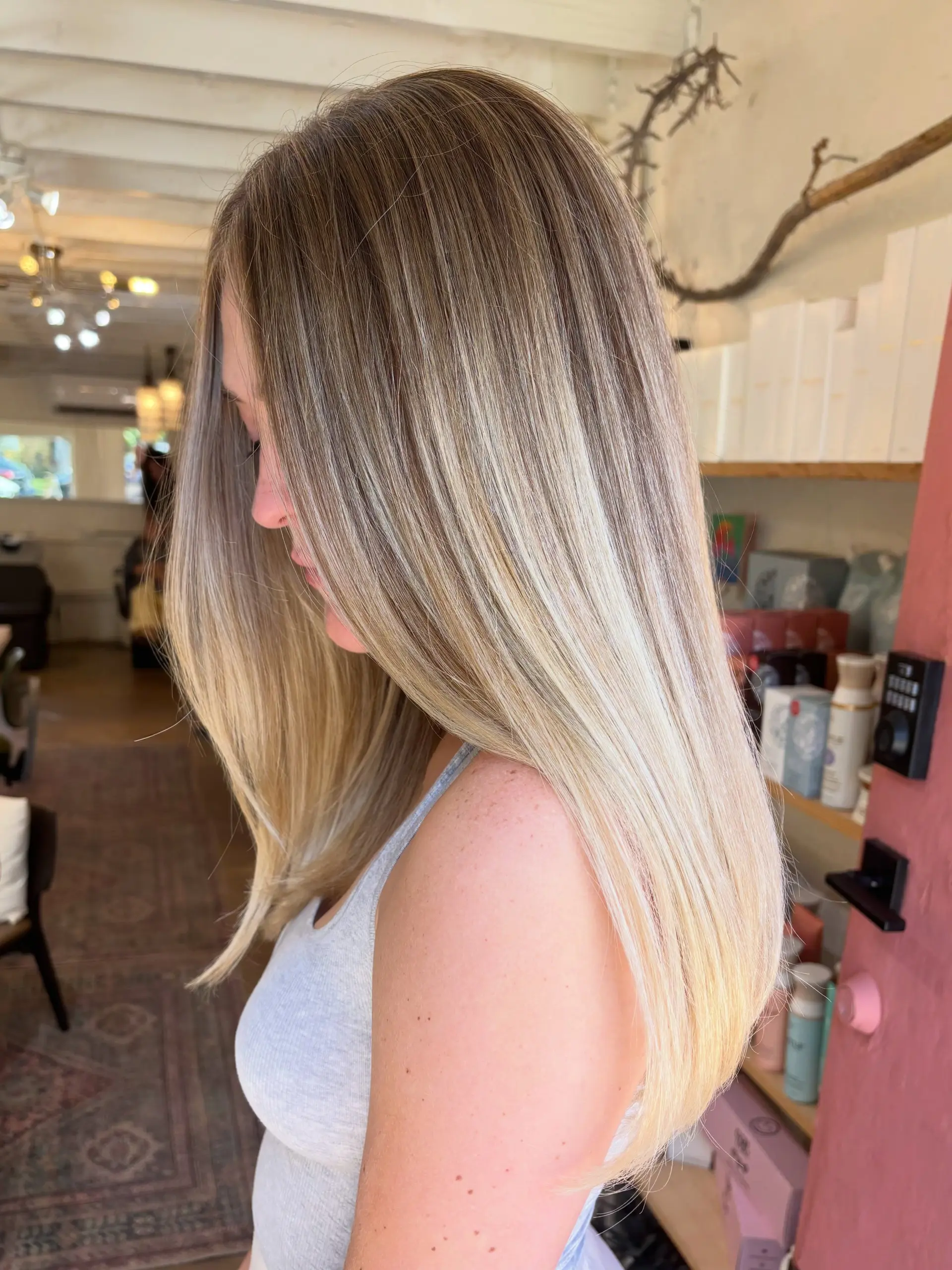 Long, sleek straight hair highlighted with seamless neutral blonde ribbons blending into a soft root. 1