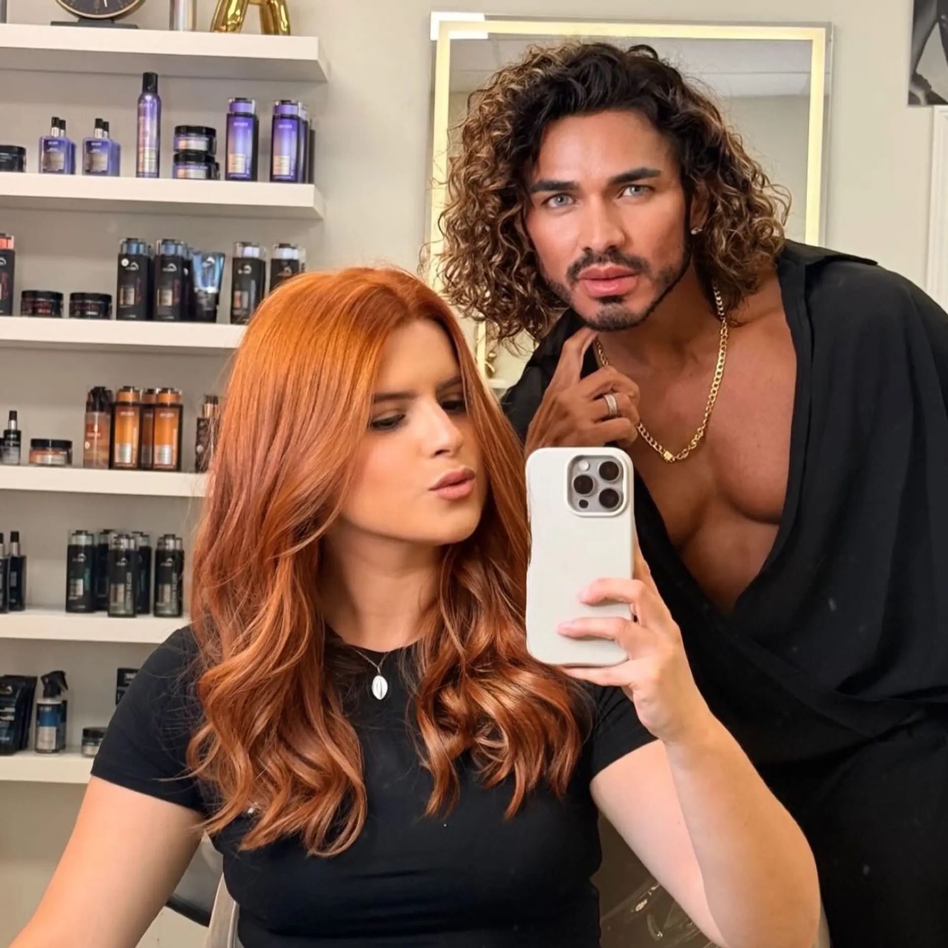 A rich copper-auburn hair color styled with loose, polished waves and a glossy finish. 1