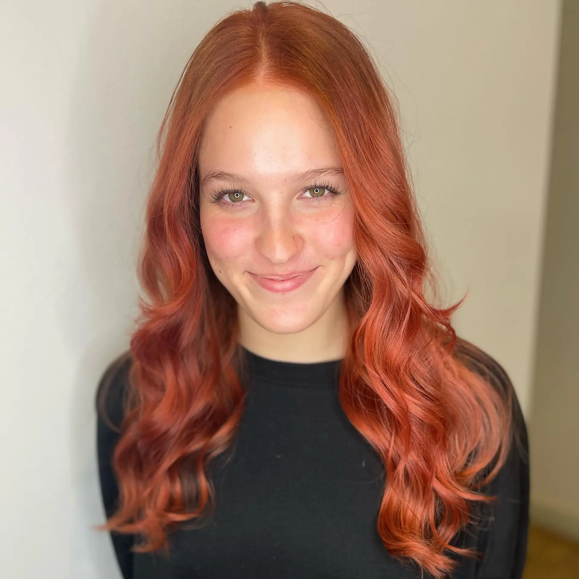 Vibrant copper-red hair parted down the middle and styled into loose, flowing waves. 1