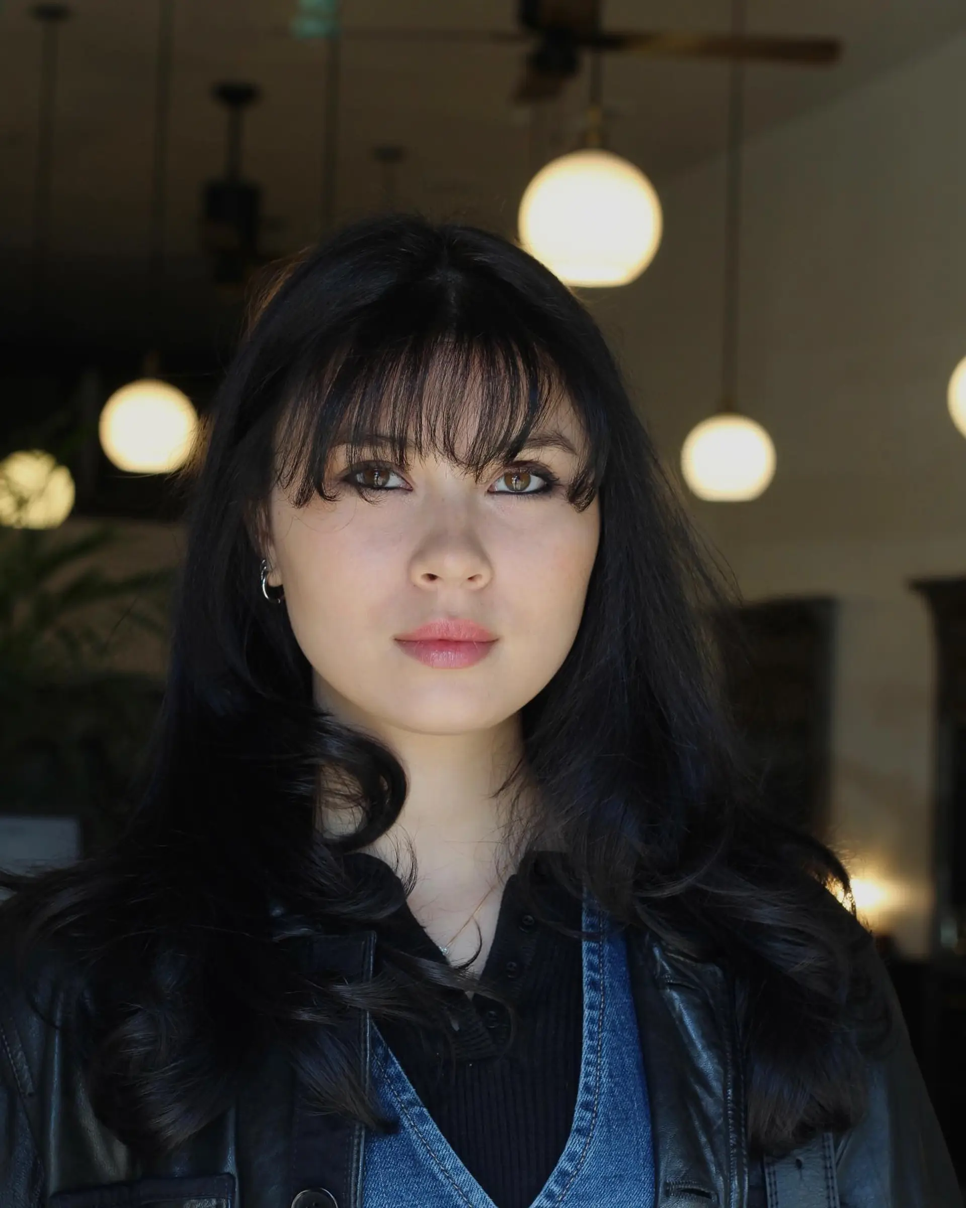 Glossy black long hair featuring textured wispy bangs and soft, loose waves around the shoulders. 1