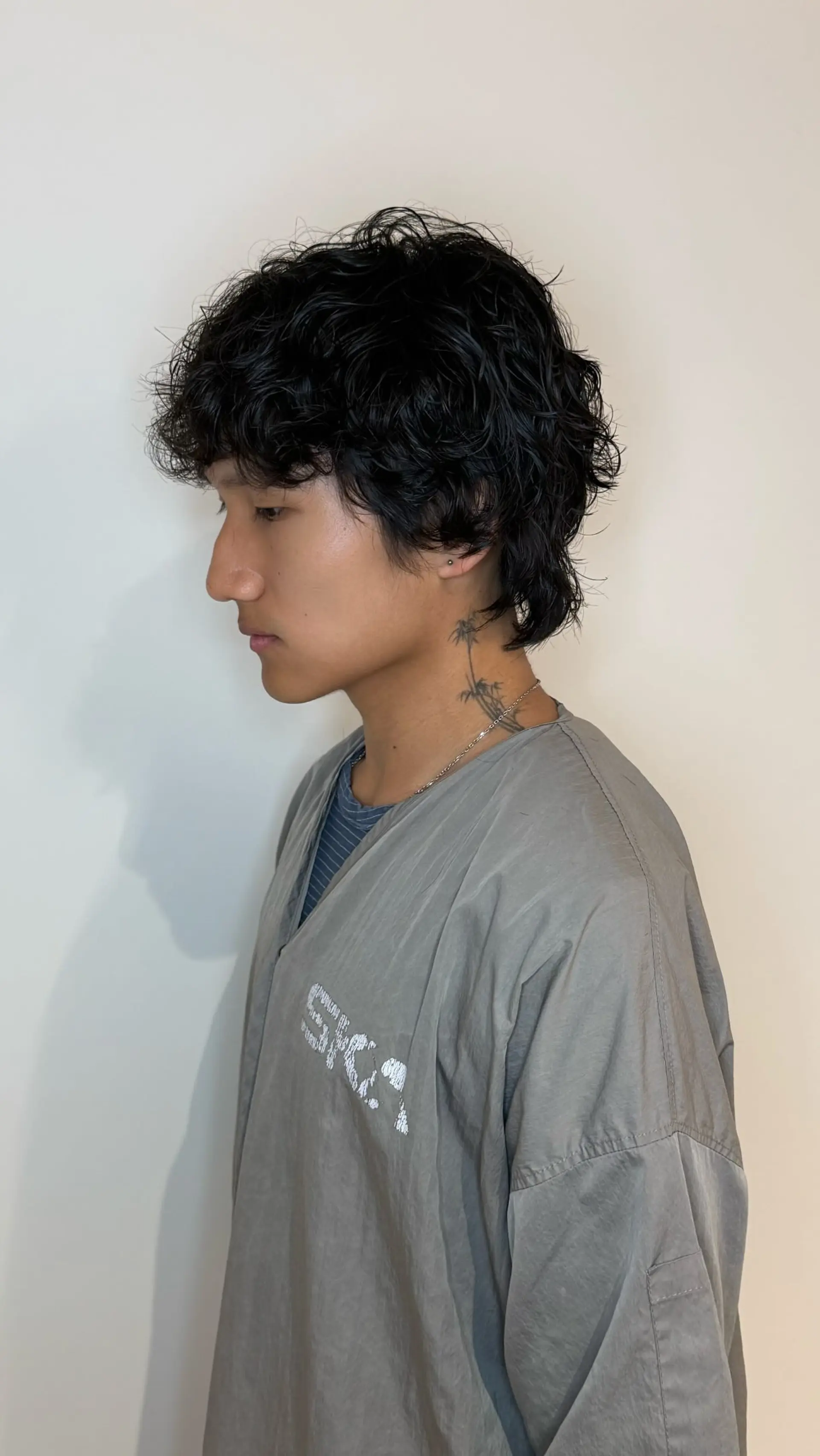 A modern wavy perm styled into a textured, layered shaggy cut with defined curls. 1