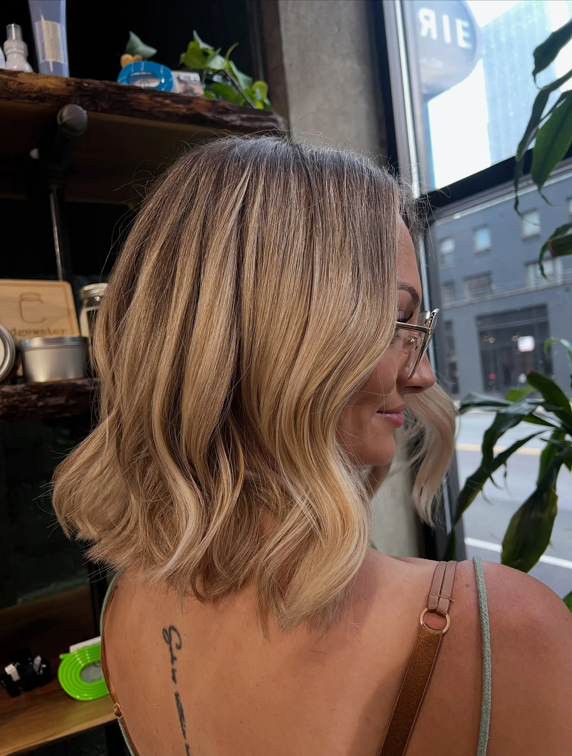 A textured neck-length bob styled with soft, undone waves and dimensional multi-tonal blonde color. 1