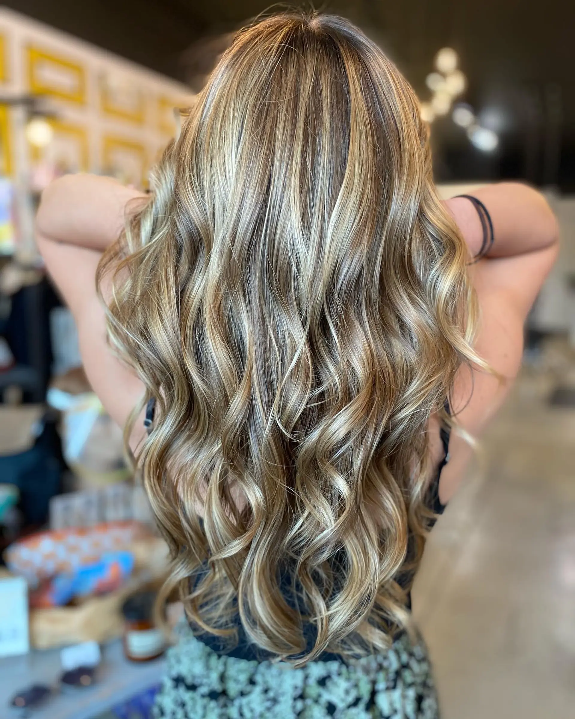 Long hair styled in soft, loose waves with multi-dimensional honey and golden blonde balayage highlights. 1