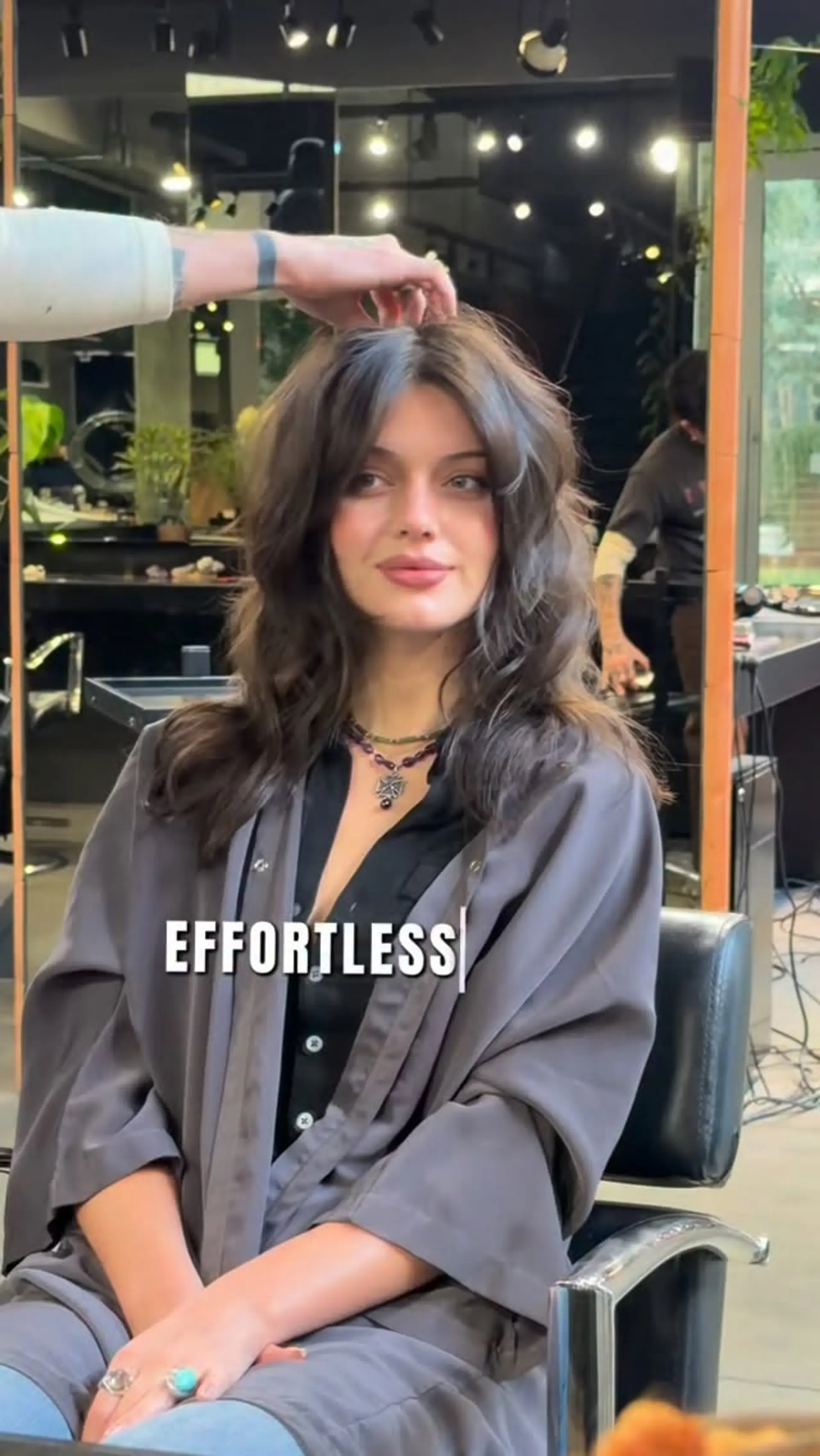 A voluminous, textured layered brunette cut styled with soft tousled waves and parted curtain bangs. 1