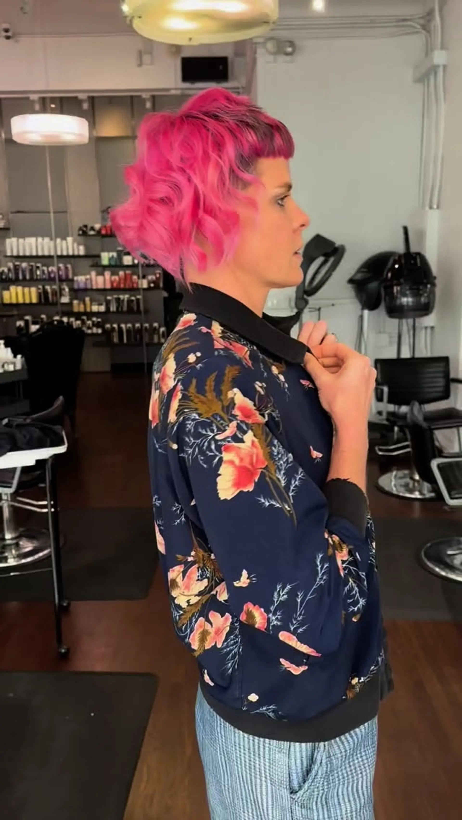 A vibrant hot pink short haircut styled with loose waves and textured micro bangs. 1