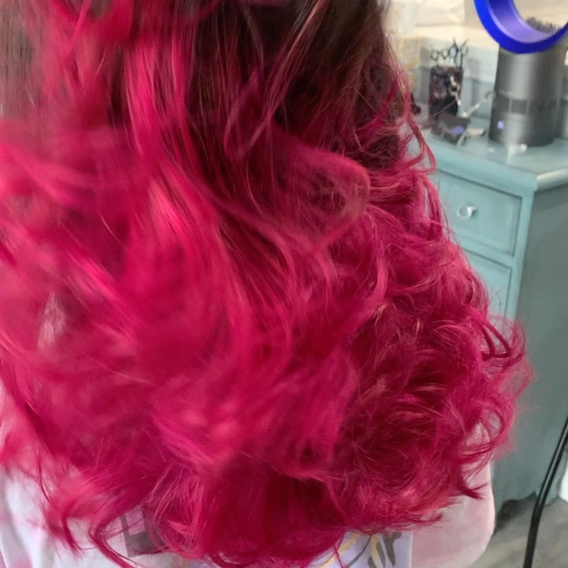 Medium-length layered hair featuring an intense vibrant fuchsia color with soft, tousled waves. 1