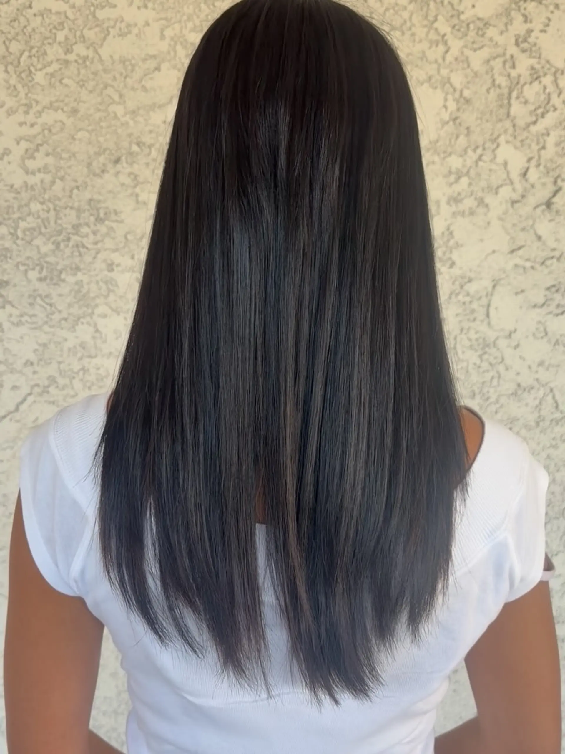 Long, glossy straight dark hair styled sleek down the back with lightly textured ends. 1