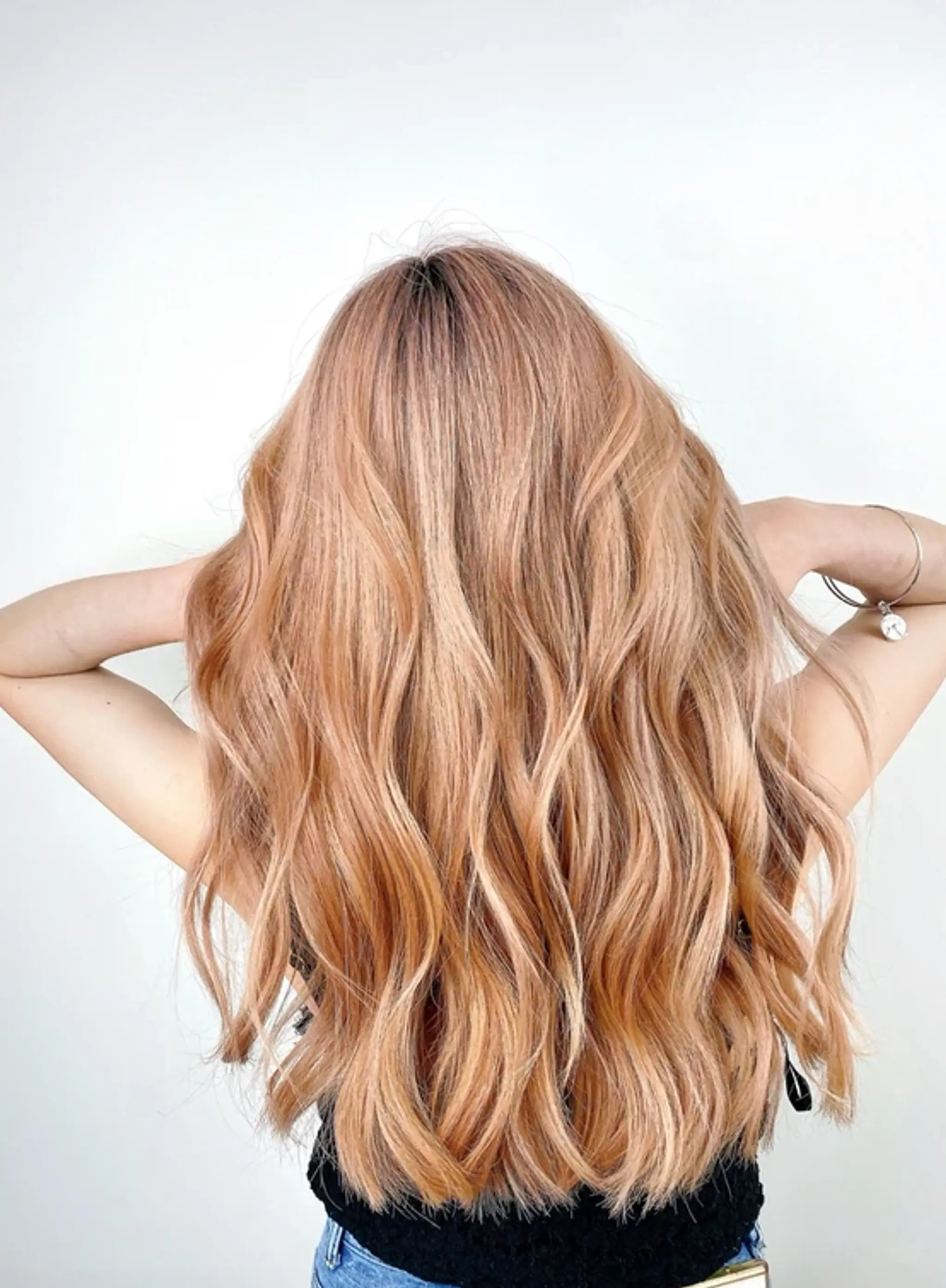 Long, honey-blonde wavy hair with a smooth and voluminous beachy look, lightly layered for movement.