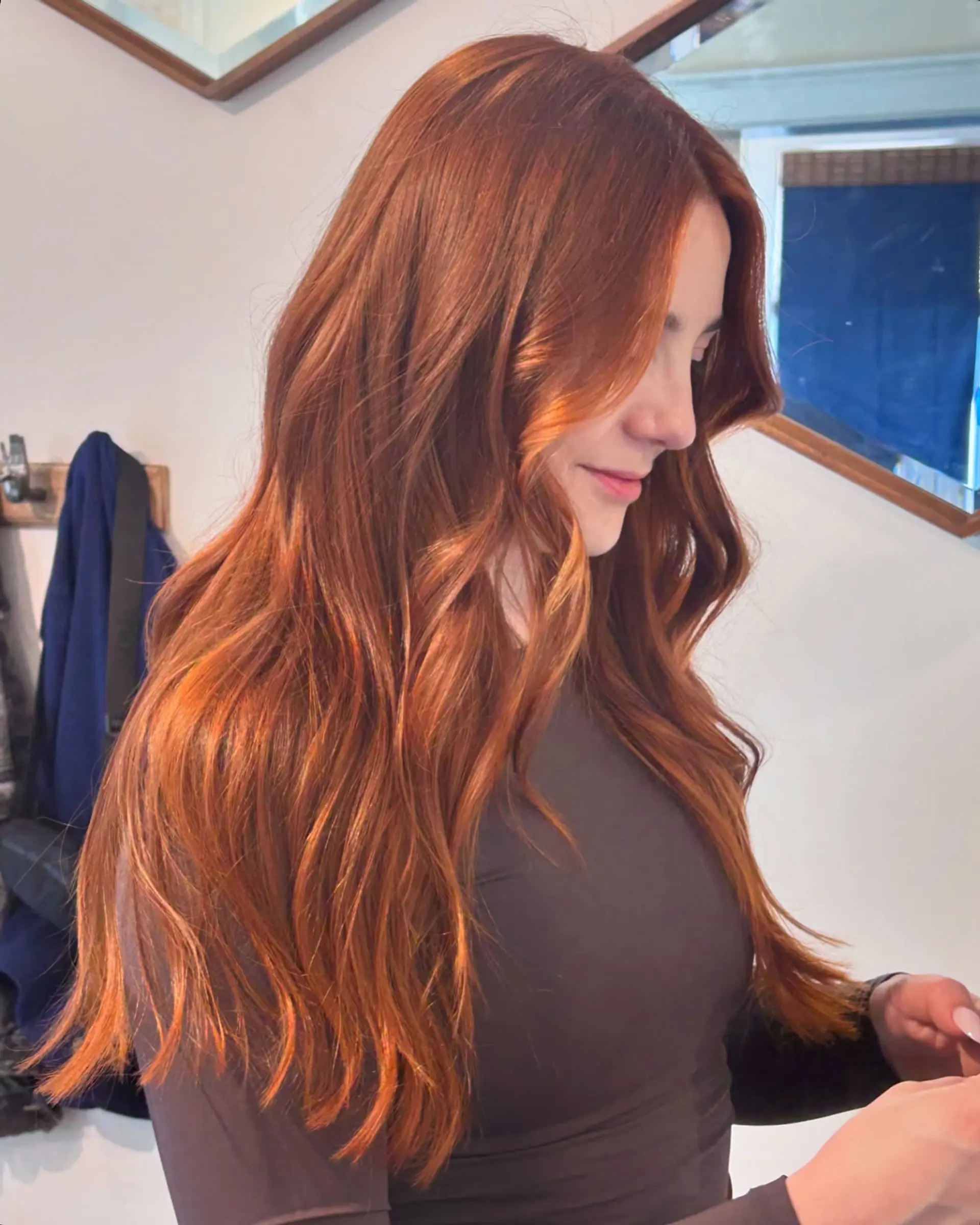 Vivid dimensional copper hair styled with soft, cascading waves and face-framing bends. 1
