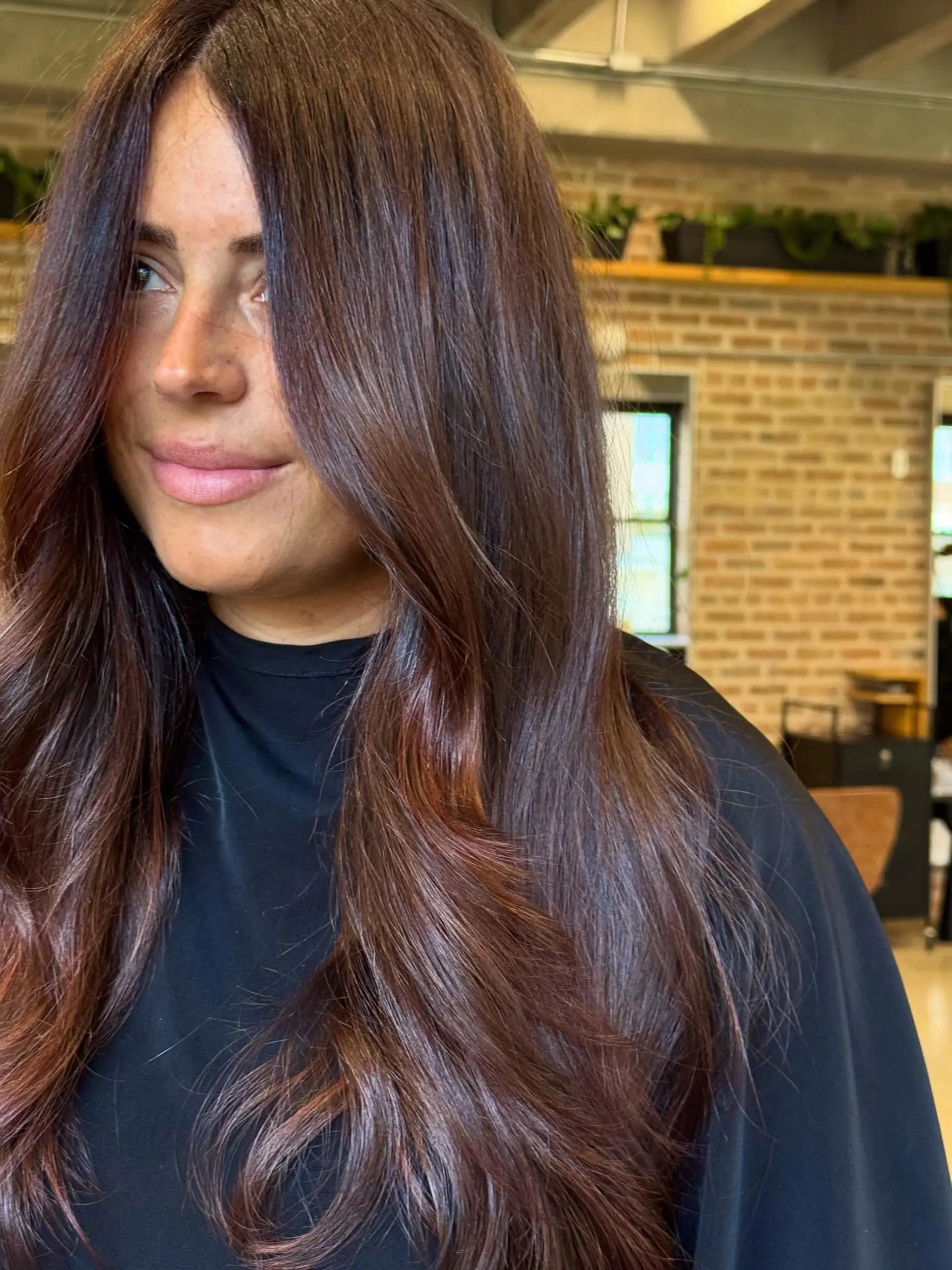A long, flowing hairstyle with a center part and soft, face-framing layers that gently cascade into natural-looking waves. The ends are styled with a soft bend, creating volume and movement. 1