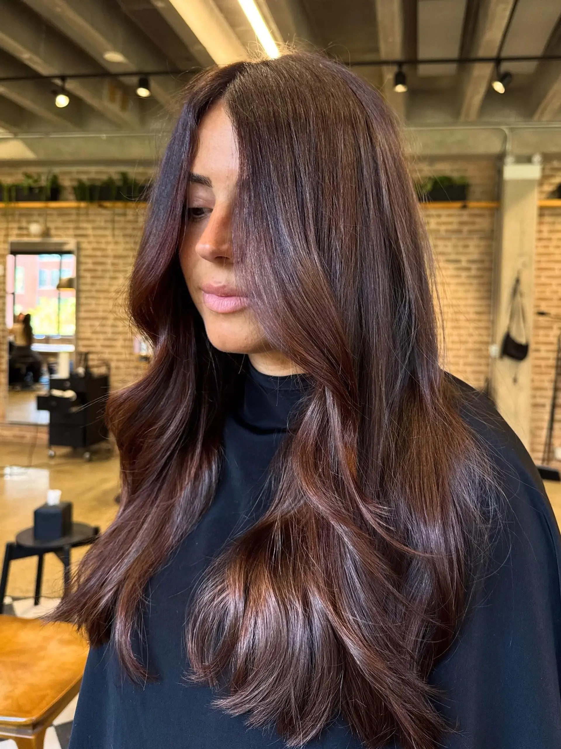 A long, flowing hairstyle with a center part and soft, face-framing layers that gently cascade into natural-looking waves. The ends are styled with a soft bend, creating volume and movement. 2