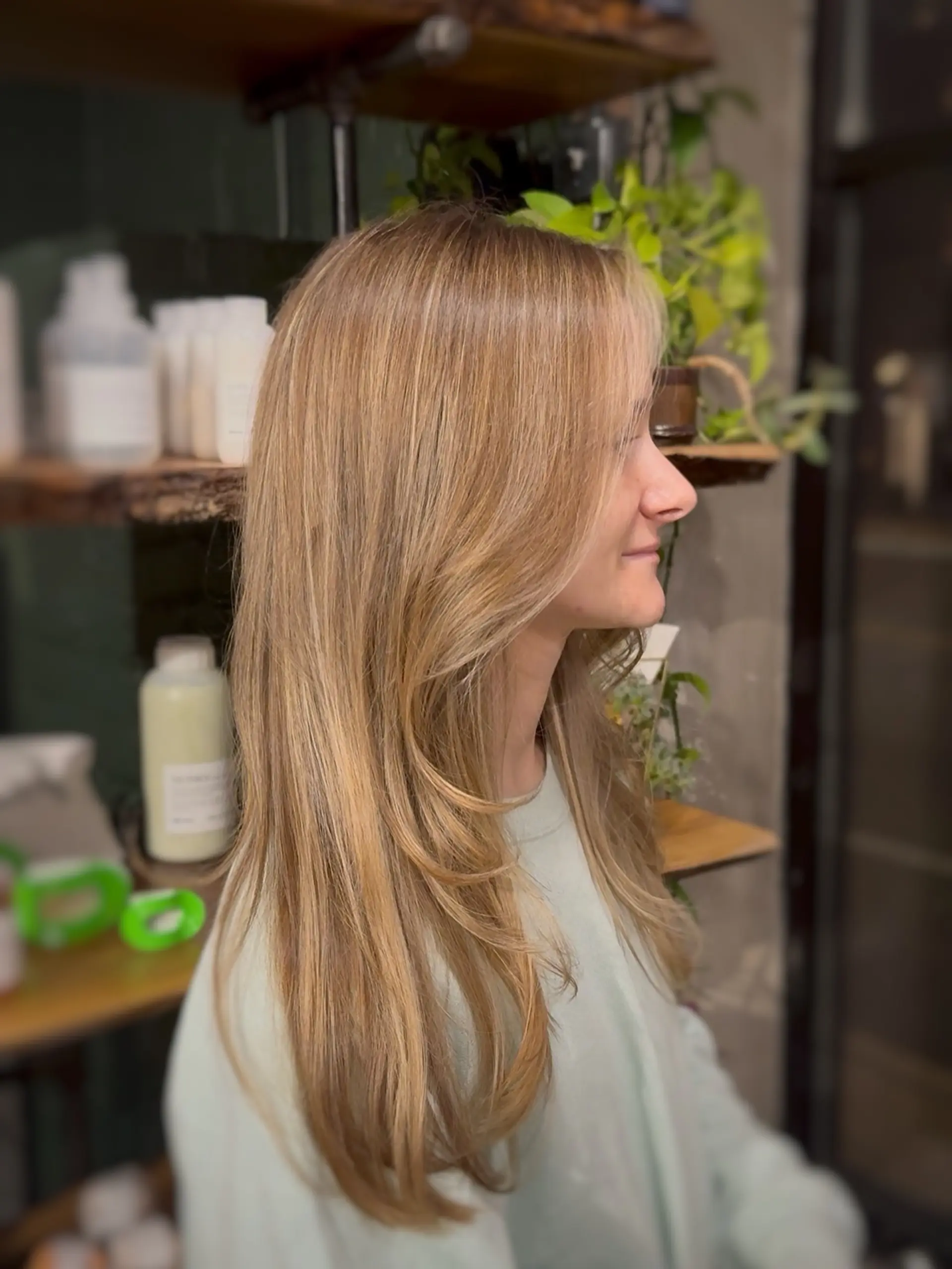 Long dimensional honey blonde hair featuring soft face-framing layers and a sleek blowout. 1