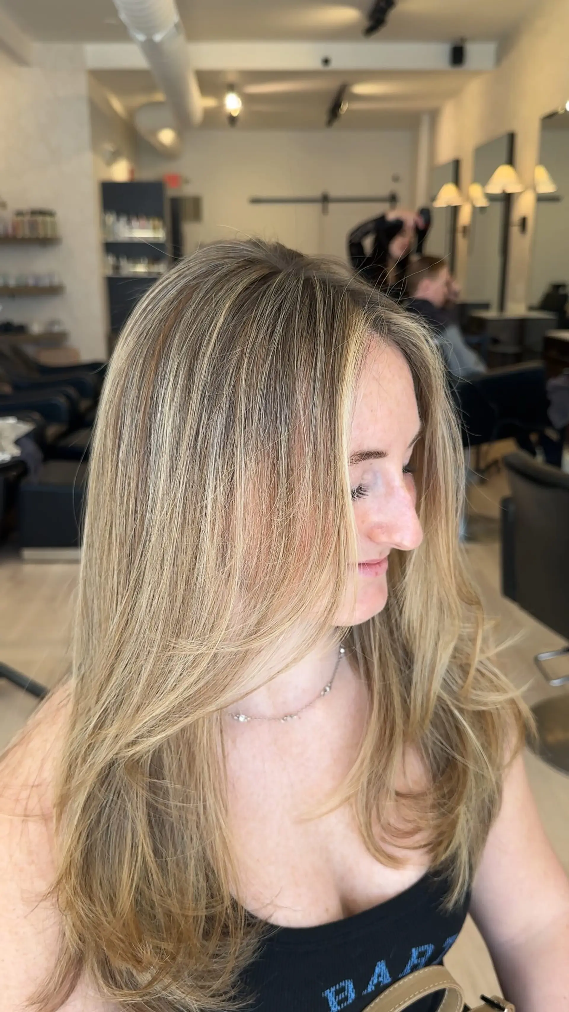 Long multi-tonal blonde hair with seamless highlights, feathered face-framing layers, and a polished salon blowout. 1