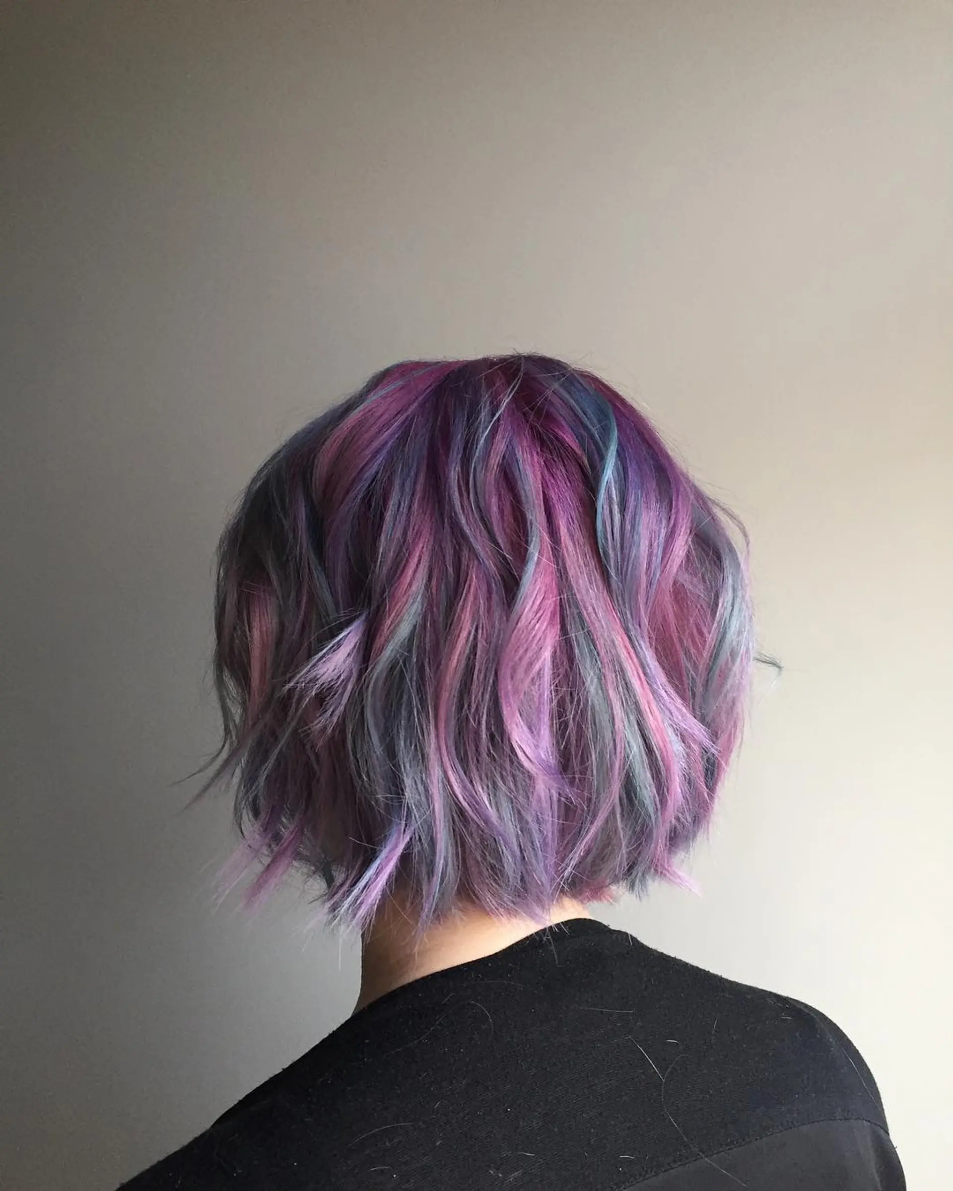 A short wavy bob with a pastel combination of pink, purple, blue and gray. 1
