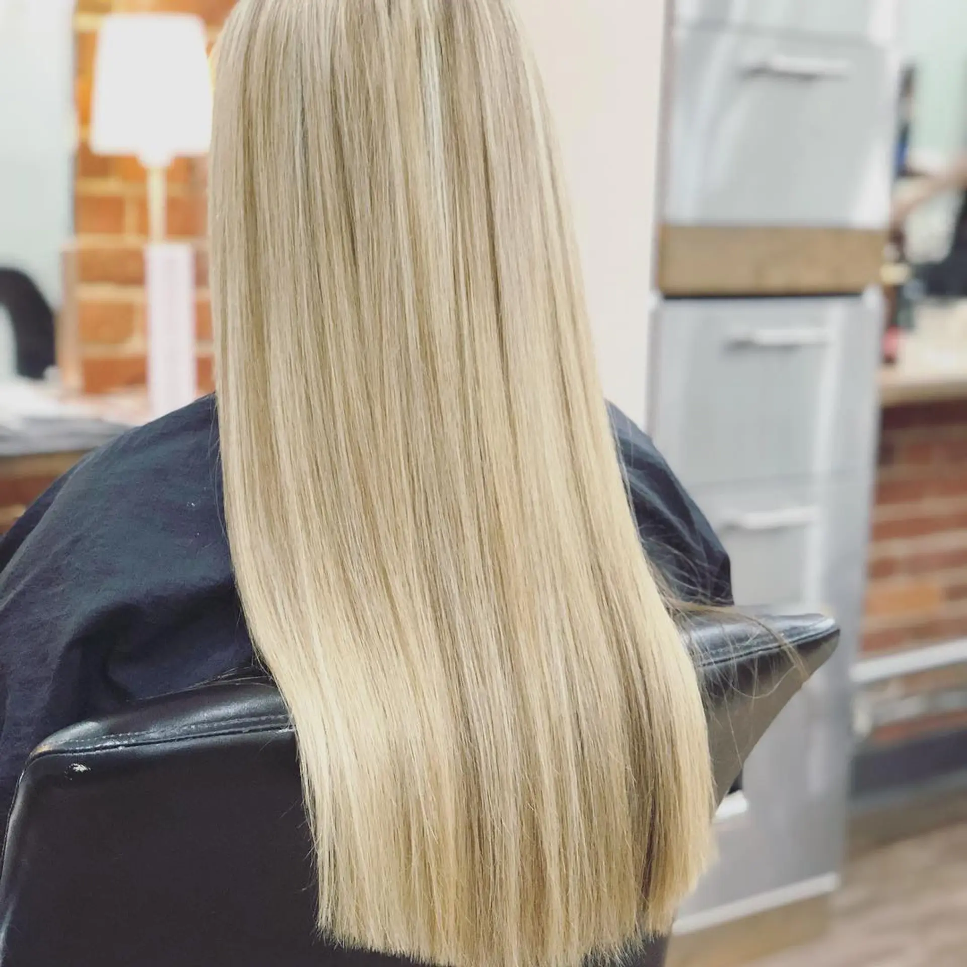 Straight, long dimensional blonde hair finished with a sharp, even blunt perimeter cut. 1