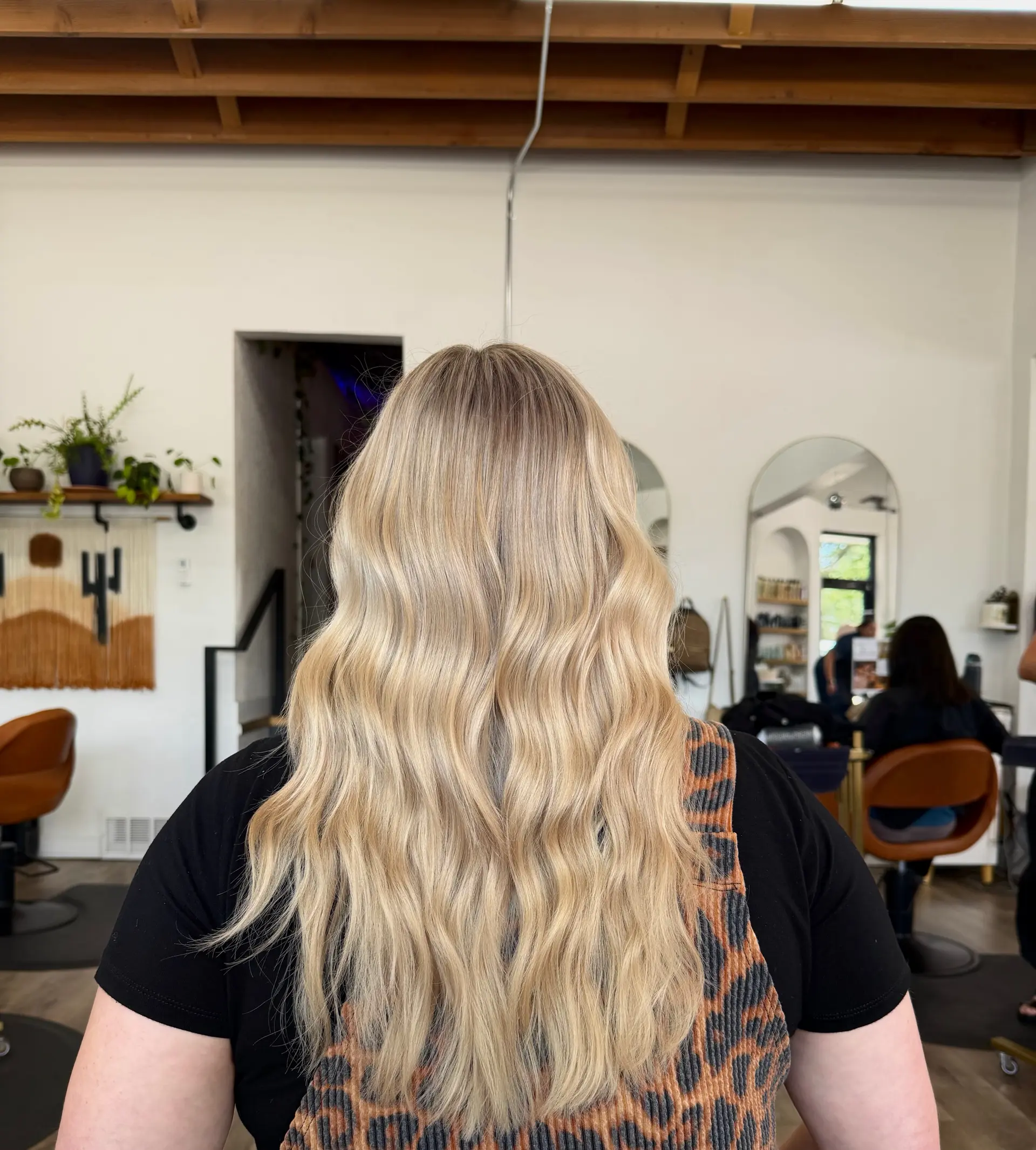 Long bright blonde hair styled with soft, dimensional waves and a subtle natural root blend. 1