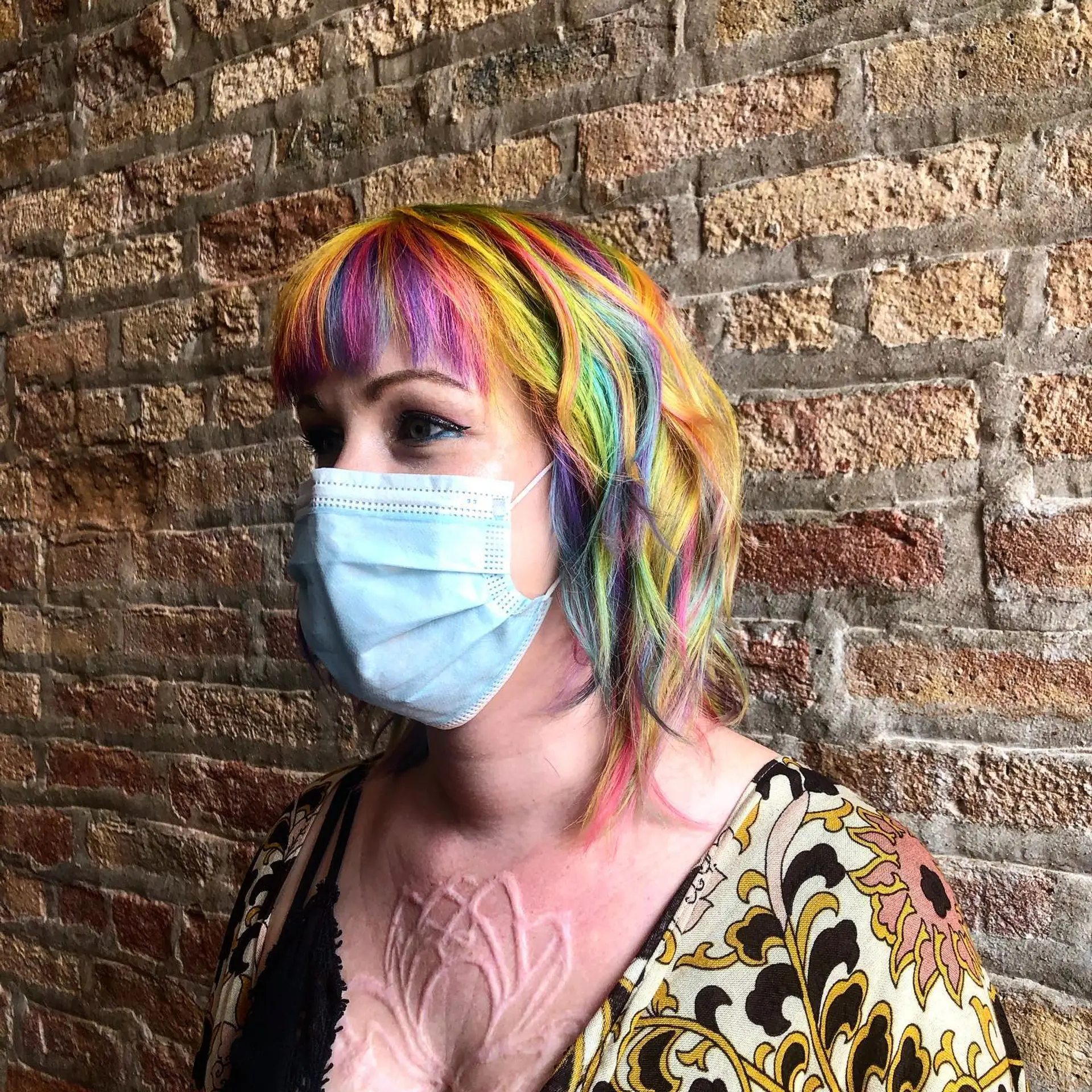 A medium-length bob with vibrant rainbow colors and blunt bangs. 1