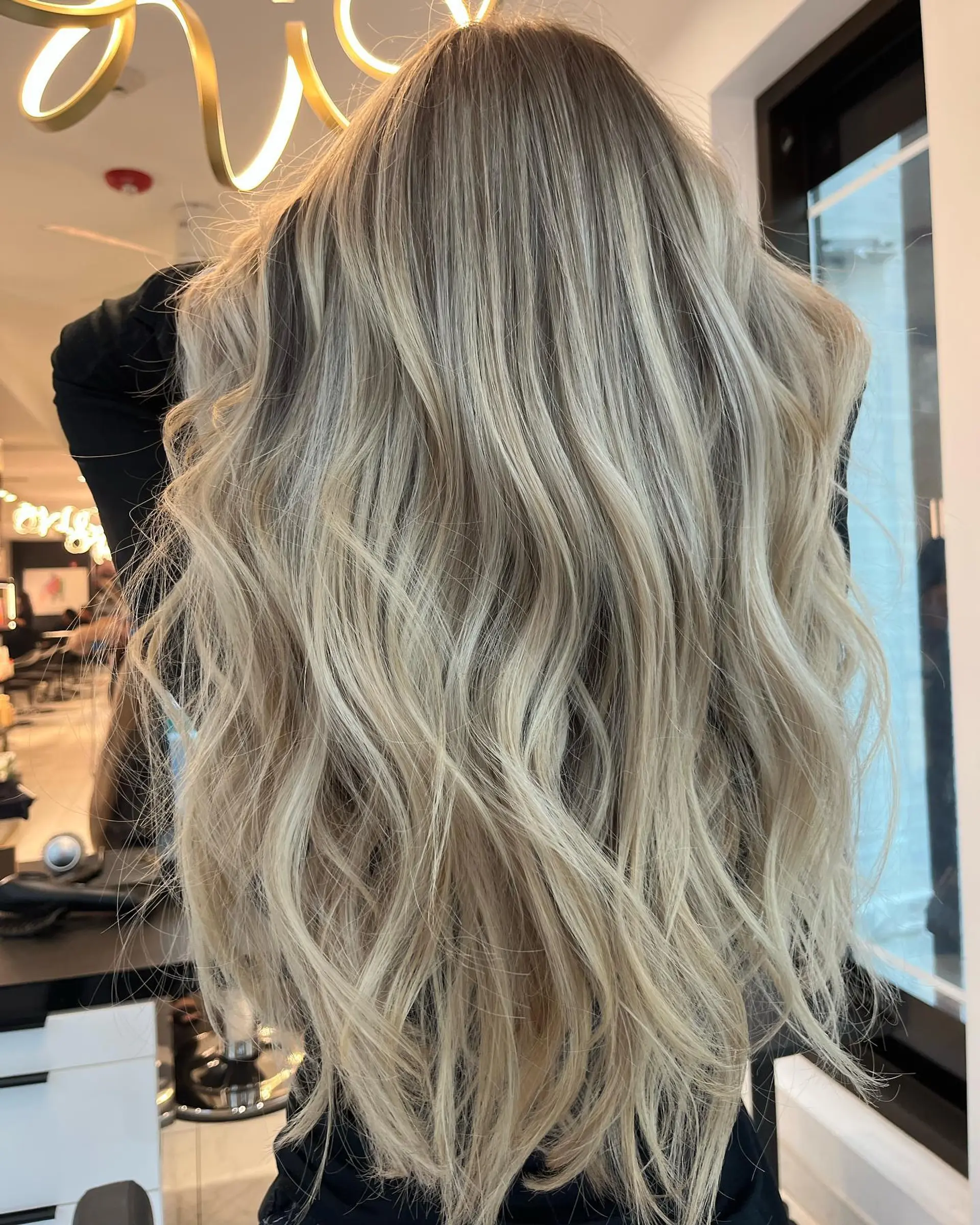 Long, wavy hair with a seamless ash blonde balayage. 1