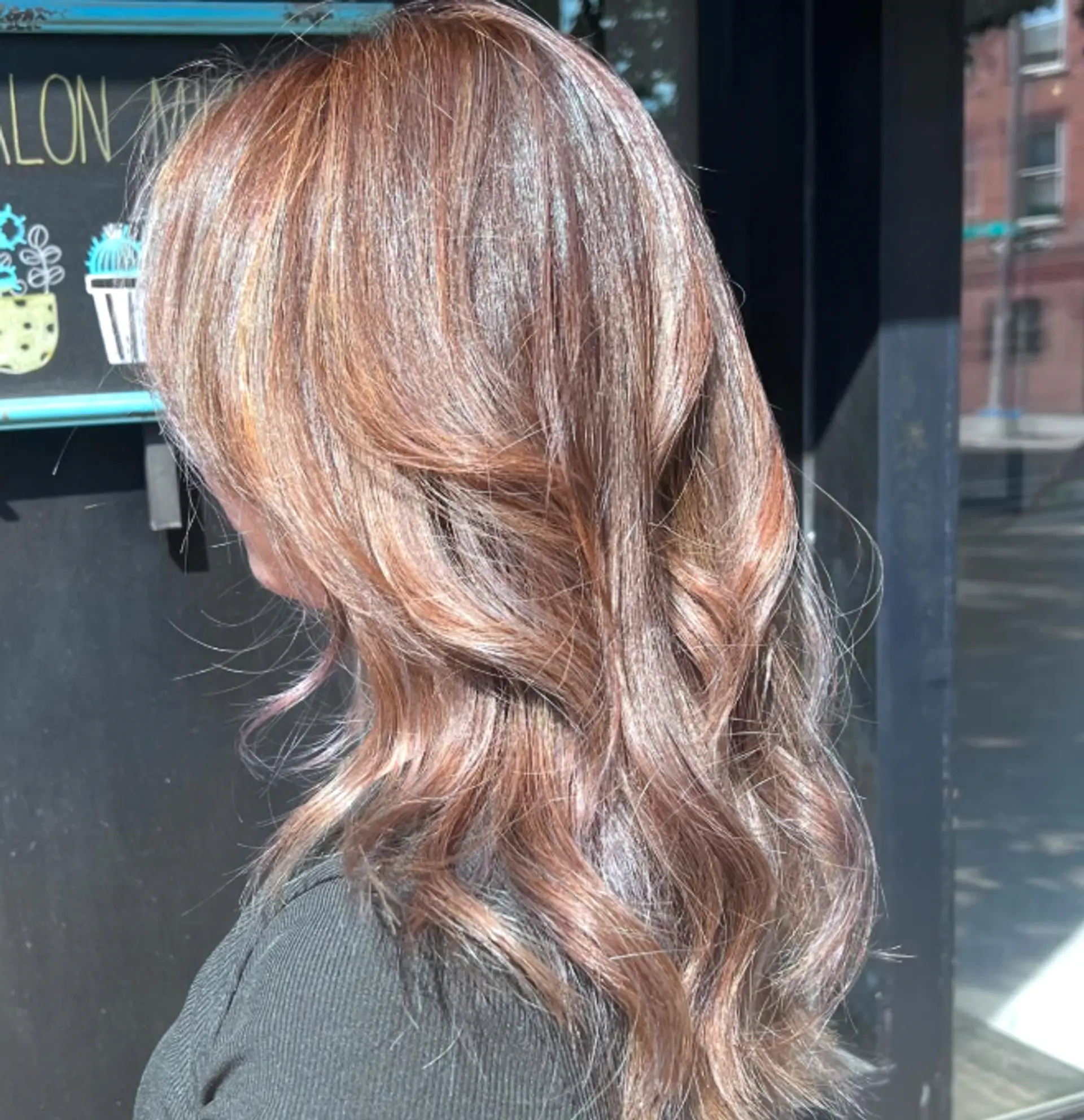 A wavy, layered hairstyle with subtle bronde coloring and highlights for a dimensional look. 1