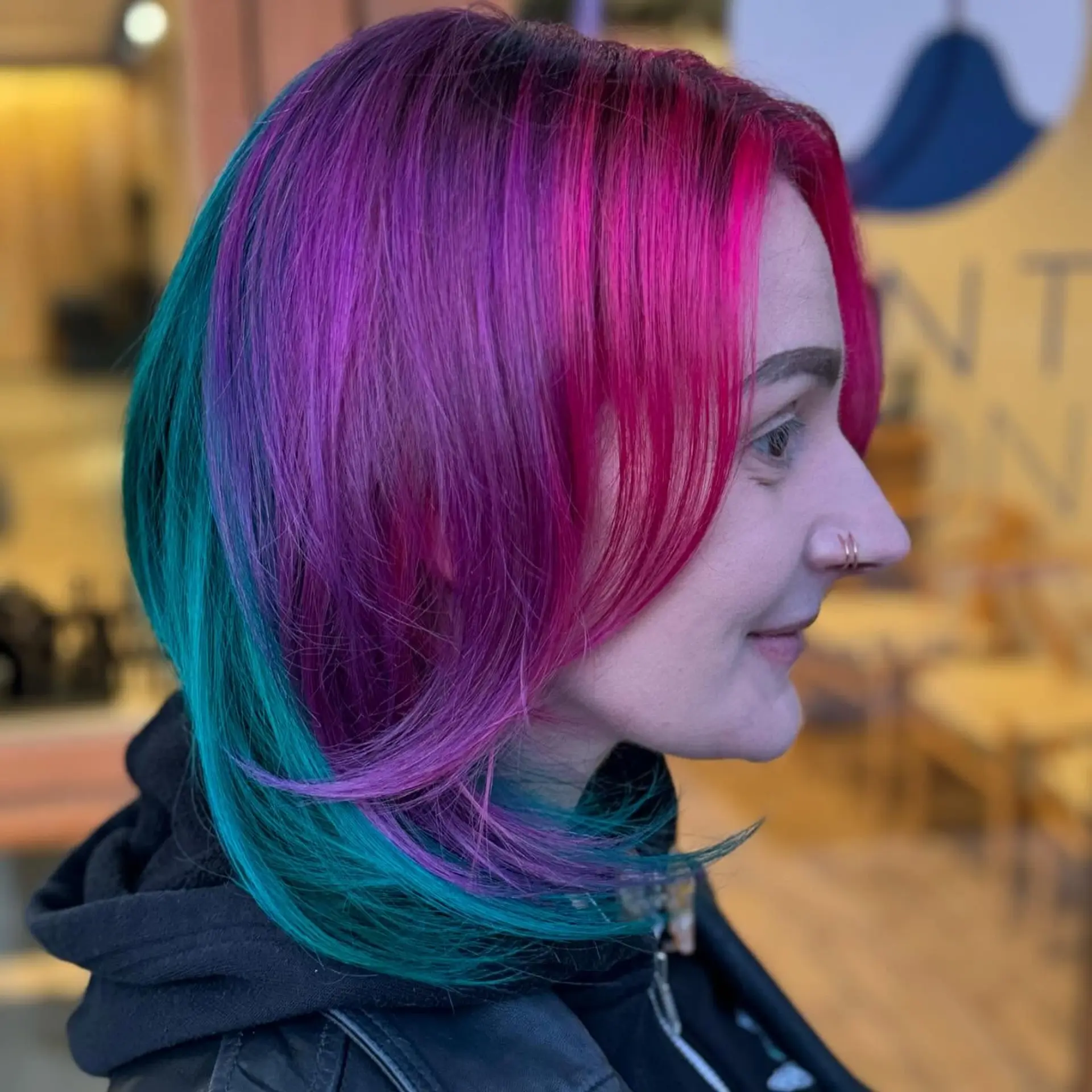 A layered shoulder-length haircut featuring bright magenta pink face-framing strands, deep purple mid-sections, and vivid teal blue layers. 1