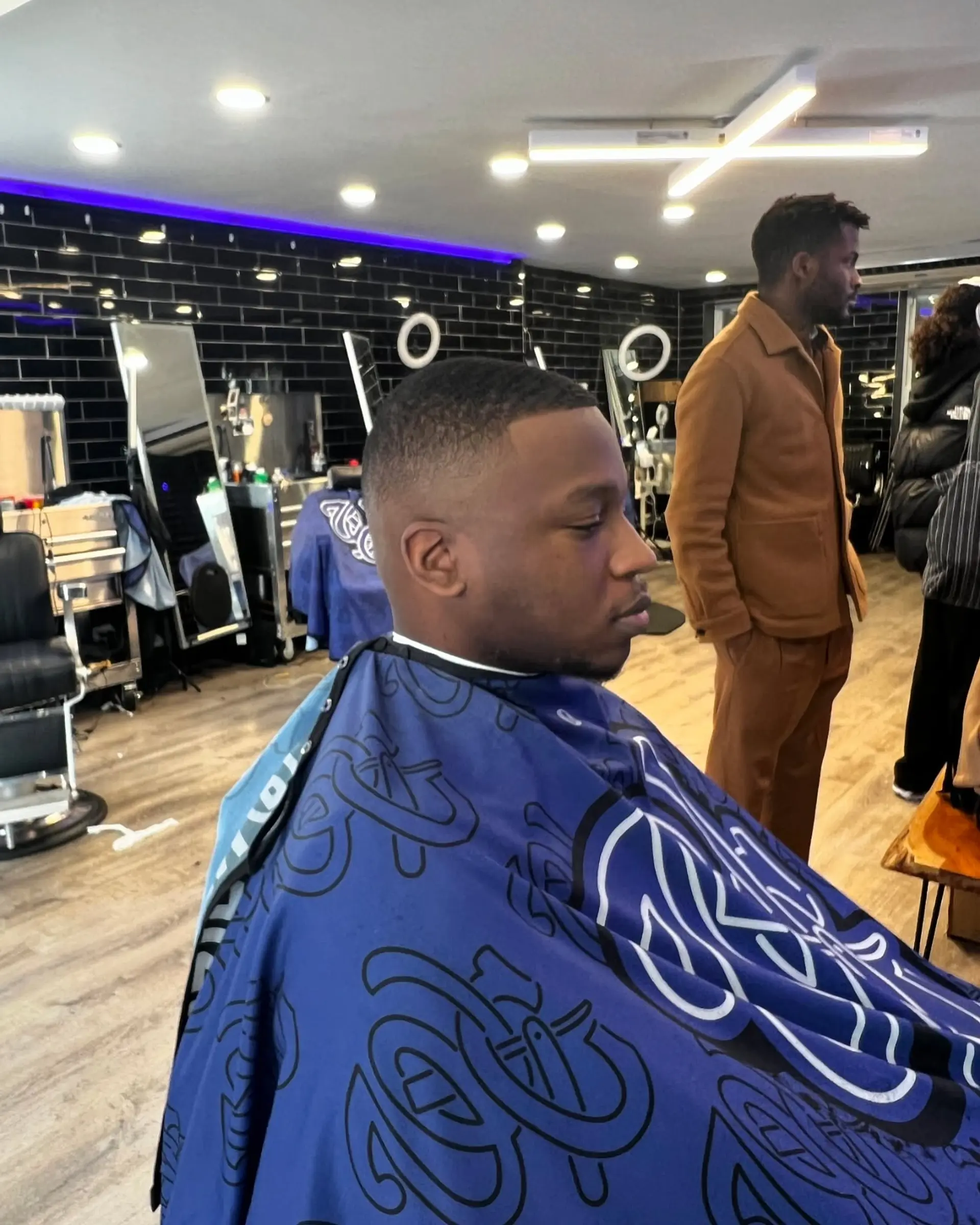 A clean short buzz cut with a smooth mid fade and sharp hairline shape up. 1