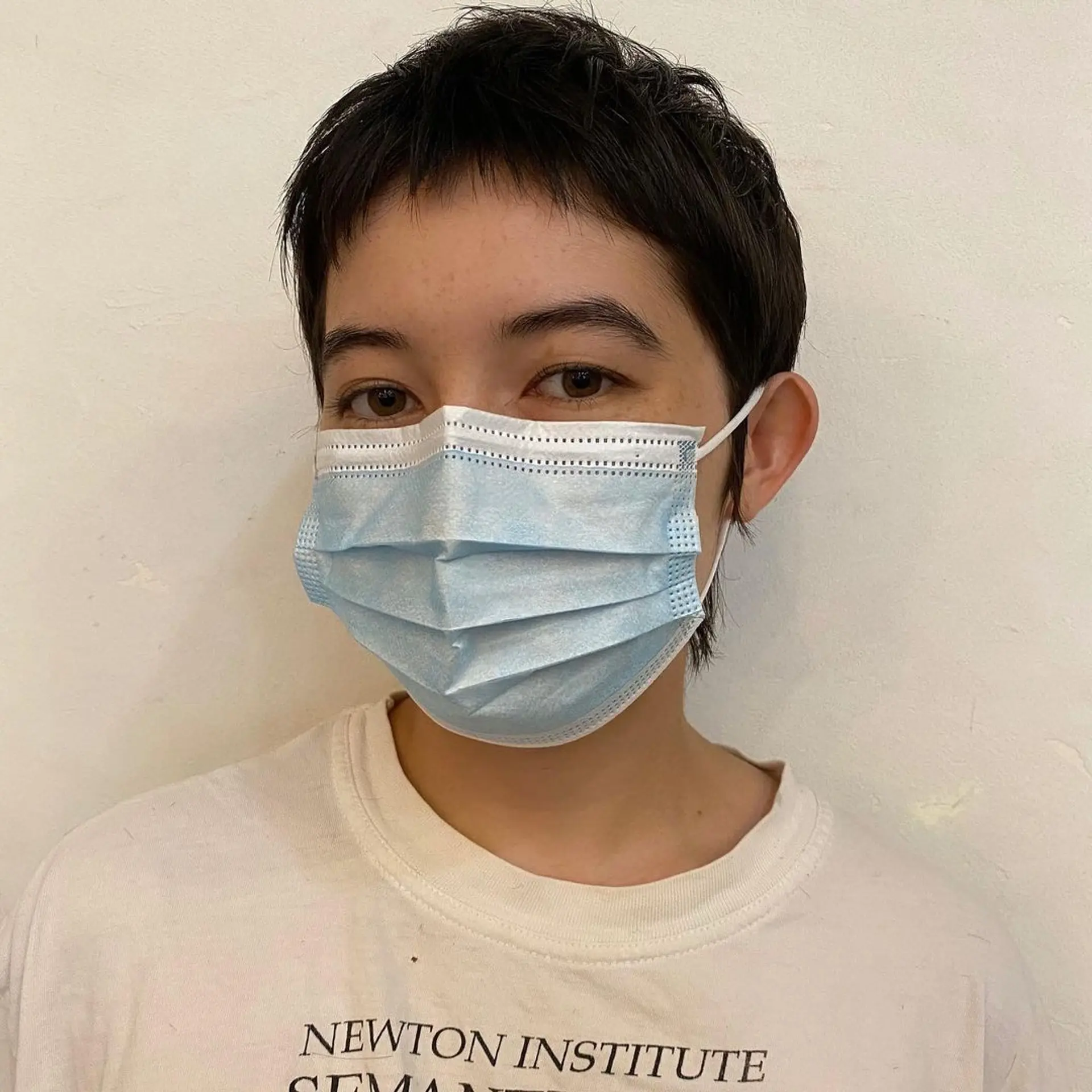 A sleek, textured pixie cut with uniformly short, dark brown hair. Features include slightly longer pieces at the crown for volume, and straight-cut bangs with a bit of unevenness for a modern, edgy look. 2