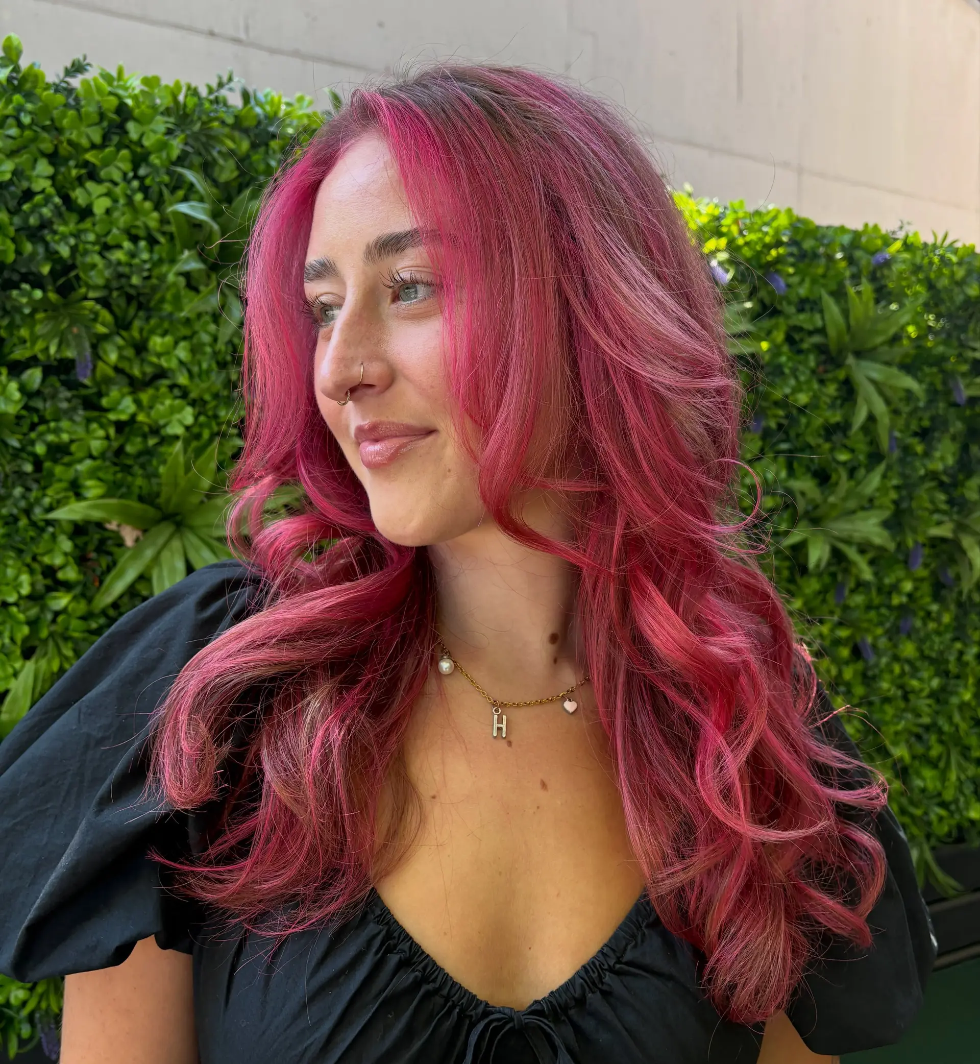 Vibrant hot pink hair styled with soft, voluminous waves and face-framing layers. 1