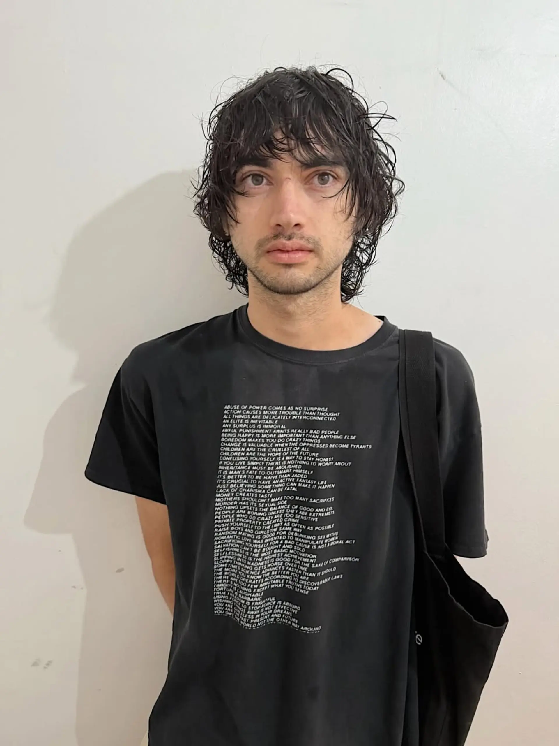 A messy, textured mid-length shag haircut featuring natural waves and a heavy fringe that subtly frames the face, creating an effortlessly cool and relaxed aesthetic. 1