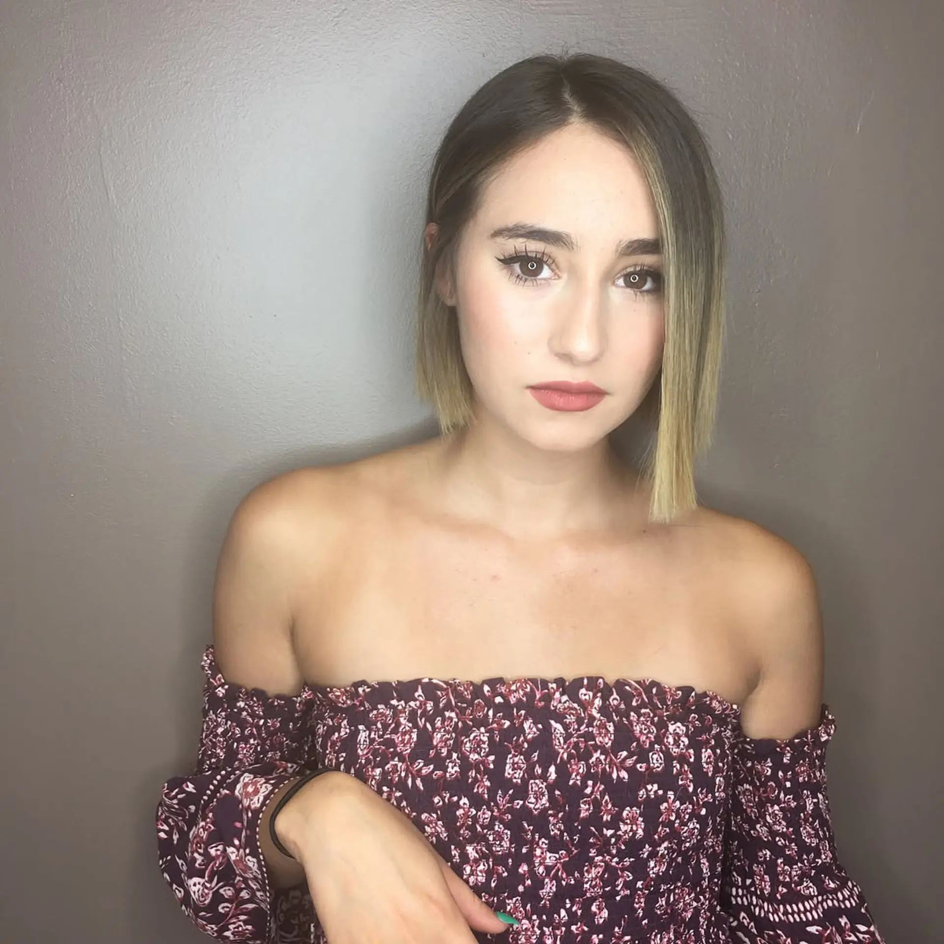 A sleek, straight asymmetrical bob with a sharp blunt edge and subtle blonde balayage. 1