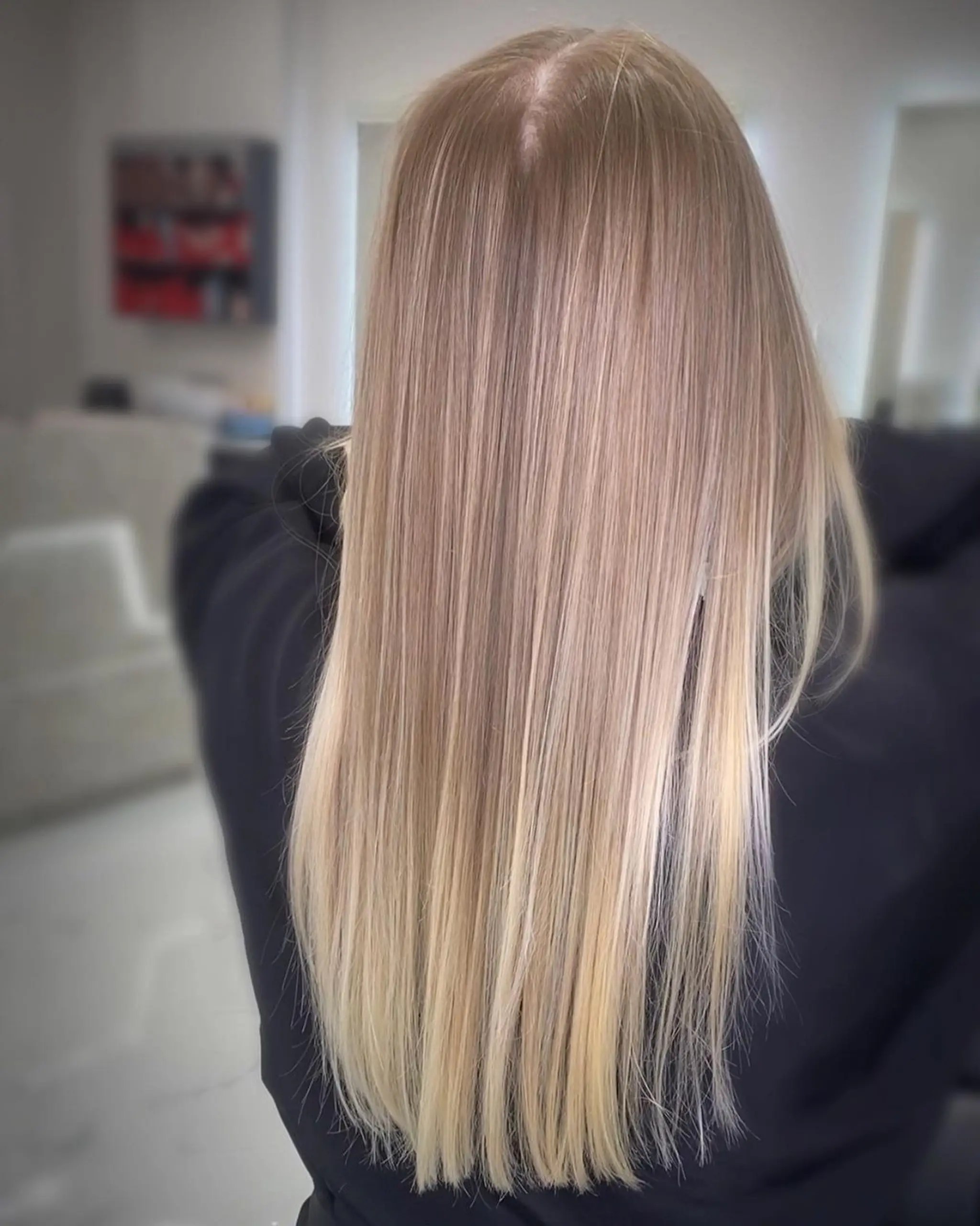 A sleek, very long hairstyle cascading down the back with a gorgeous blend of blonde, honey blonde, and subtle platinum highlights. The hair is straight and glossy, epitomizing elegance and sophisticated charm.