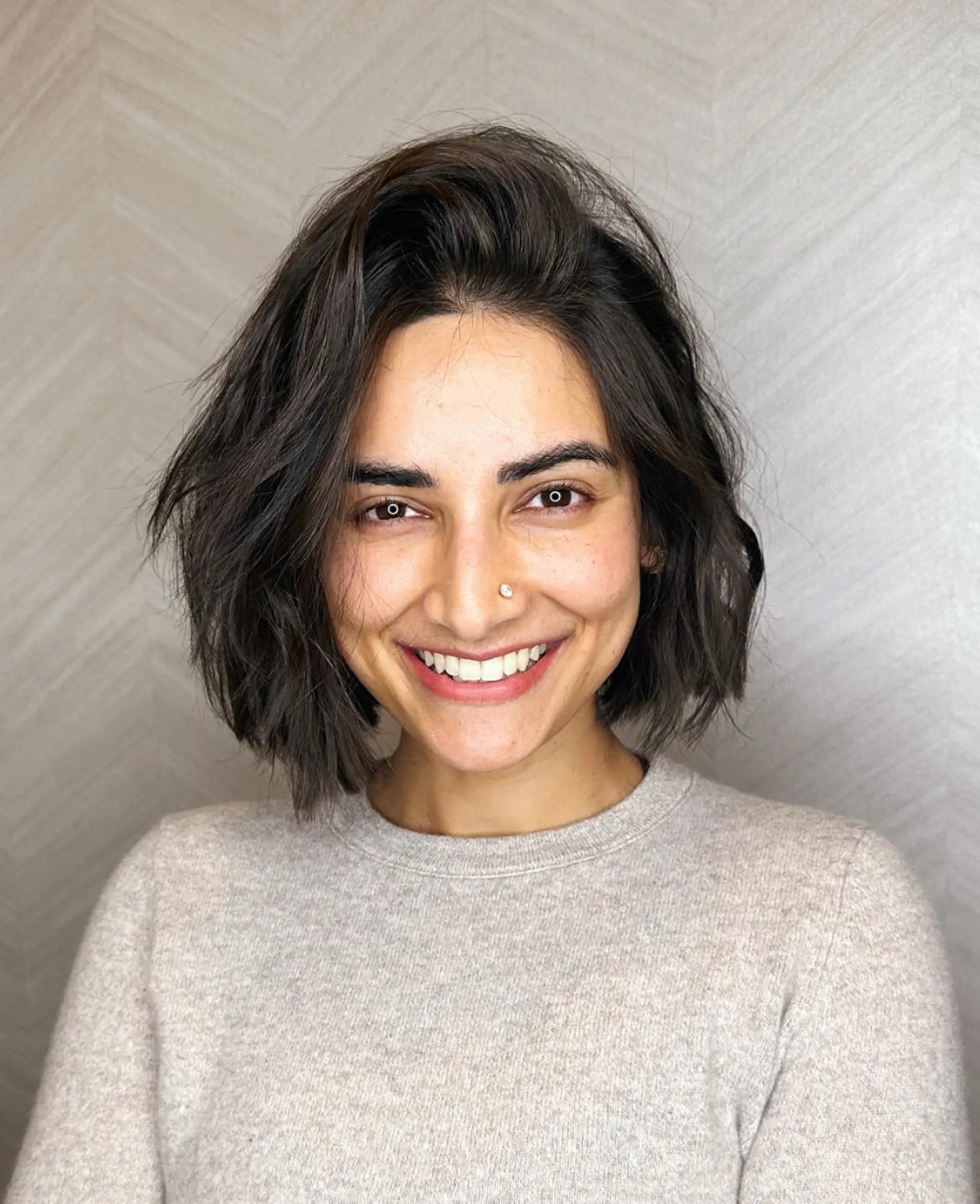 This is a short bob hairstyle characterized by dark brown waves, soft layers, and a tousled, casual look.

Cut and style by @juliamannino_hair
Color by @simabeautynyc 1