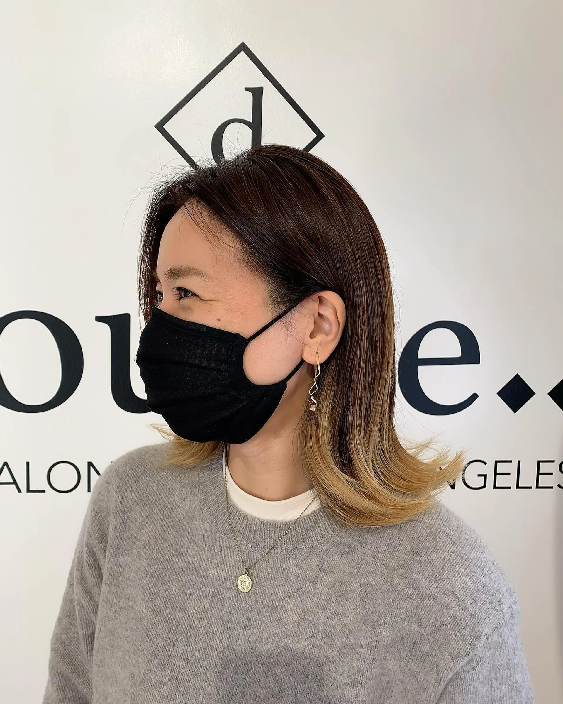 A shoulder-length lob featuring a seamless brown-to-blonde ombre with playful flipped-out ends. 1
