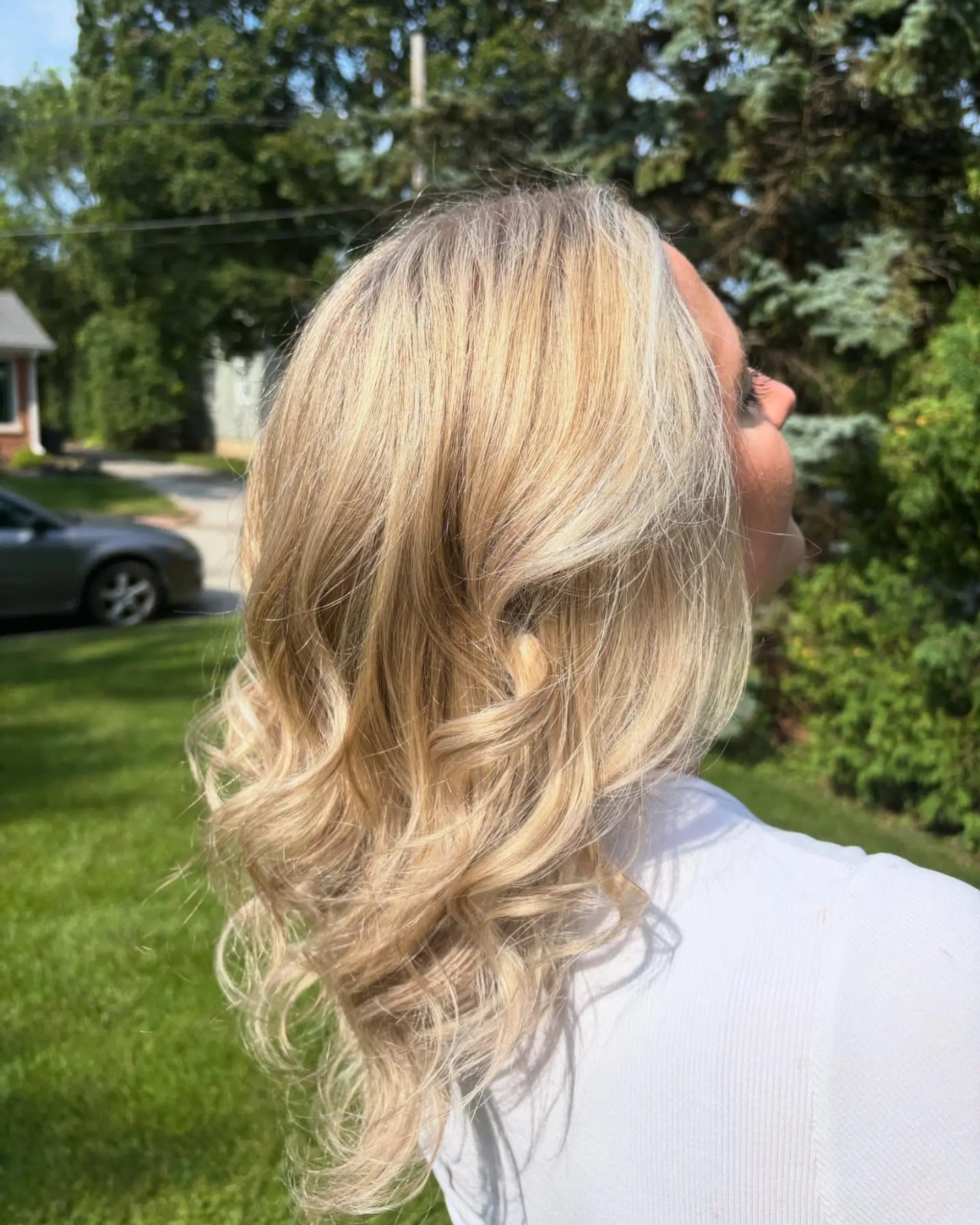 Medium-length dimensional blonde hair with multi-tonal highlights, styled in loose, bouncy waves. 1