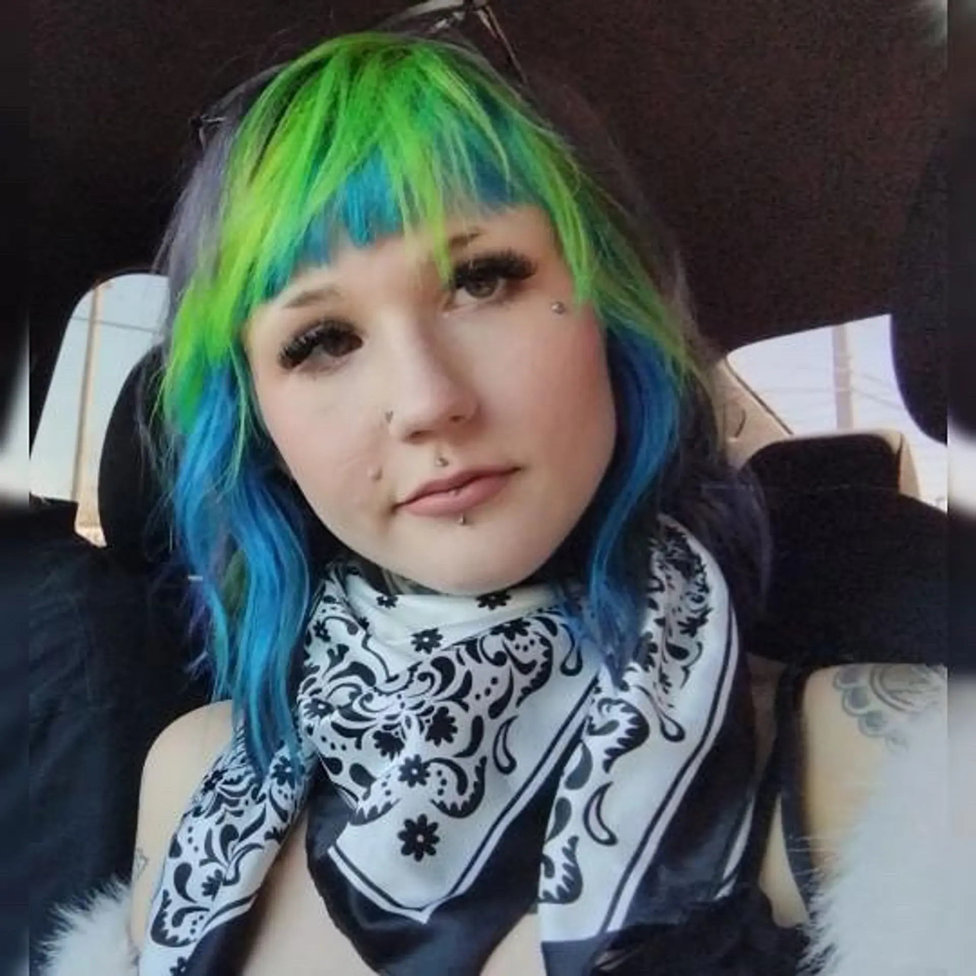 A layered shag haircut featuring blunt micro bangs and vibrant color-blocked neon green and electric blue tones over a dark base. 1