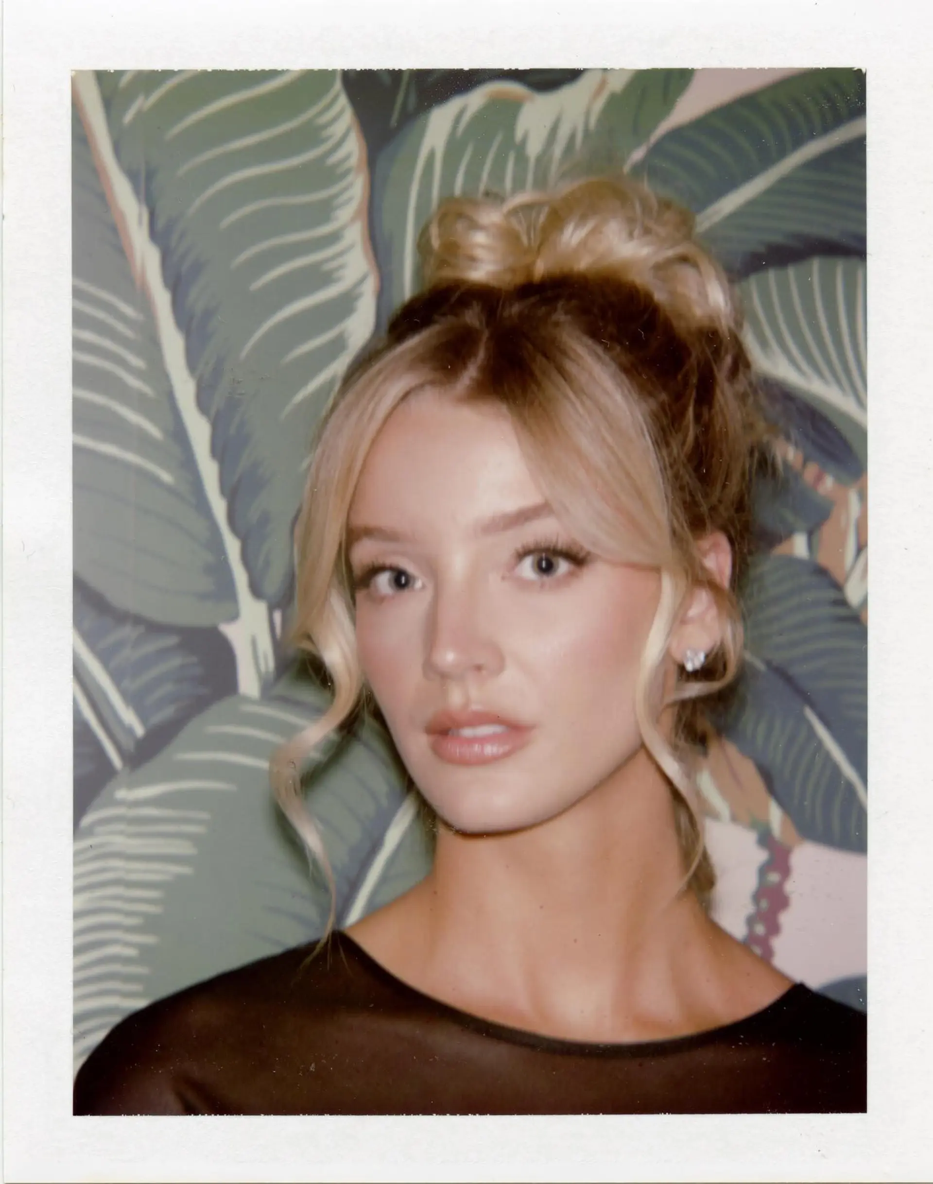 A glamorous high bun updo featuring soft, wavy face-framing tendrils and a center part. 1