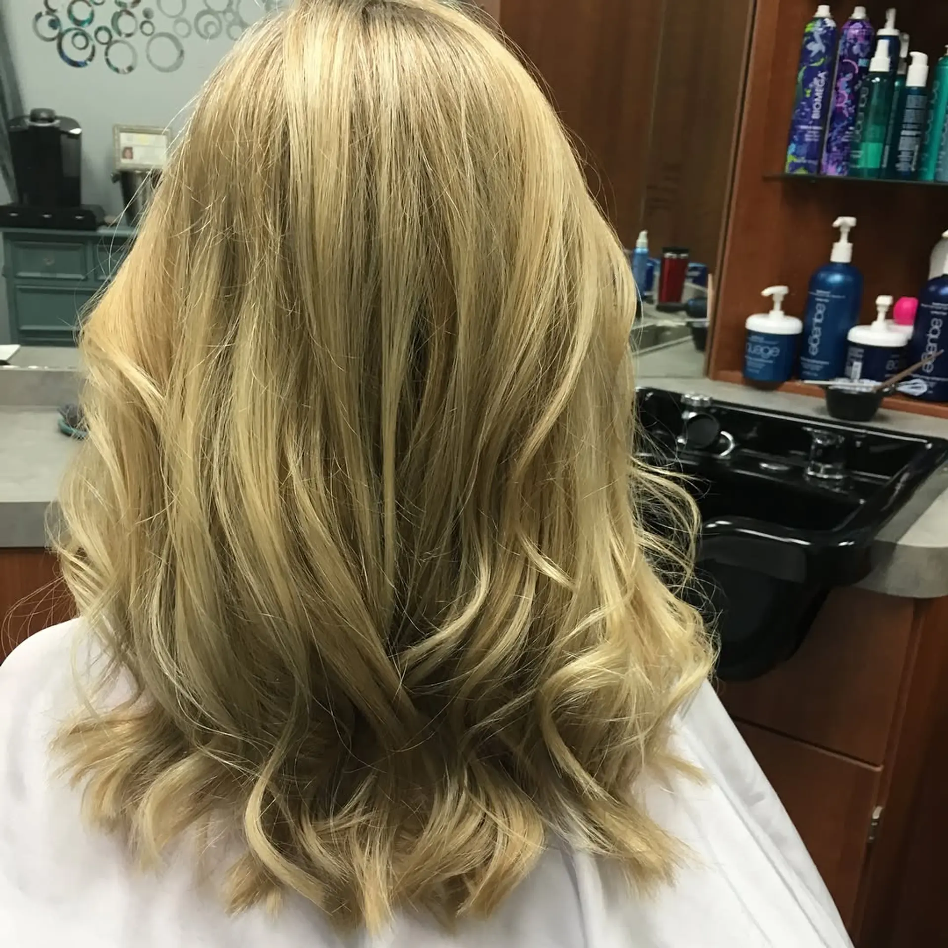Shoulder-length warm golden blonde hair styled into soft, loose waves. 1