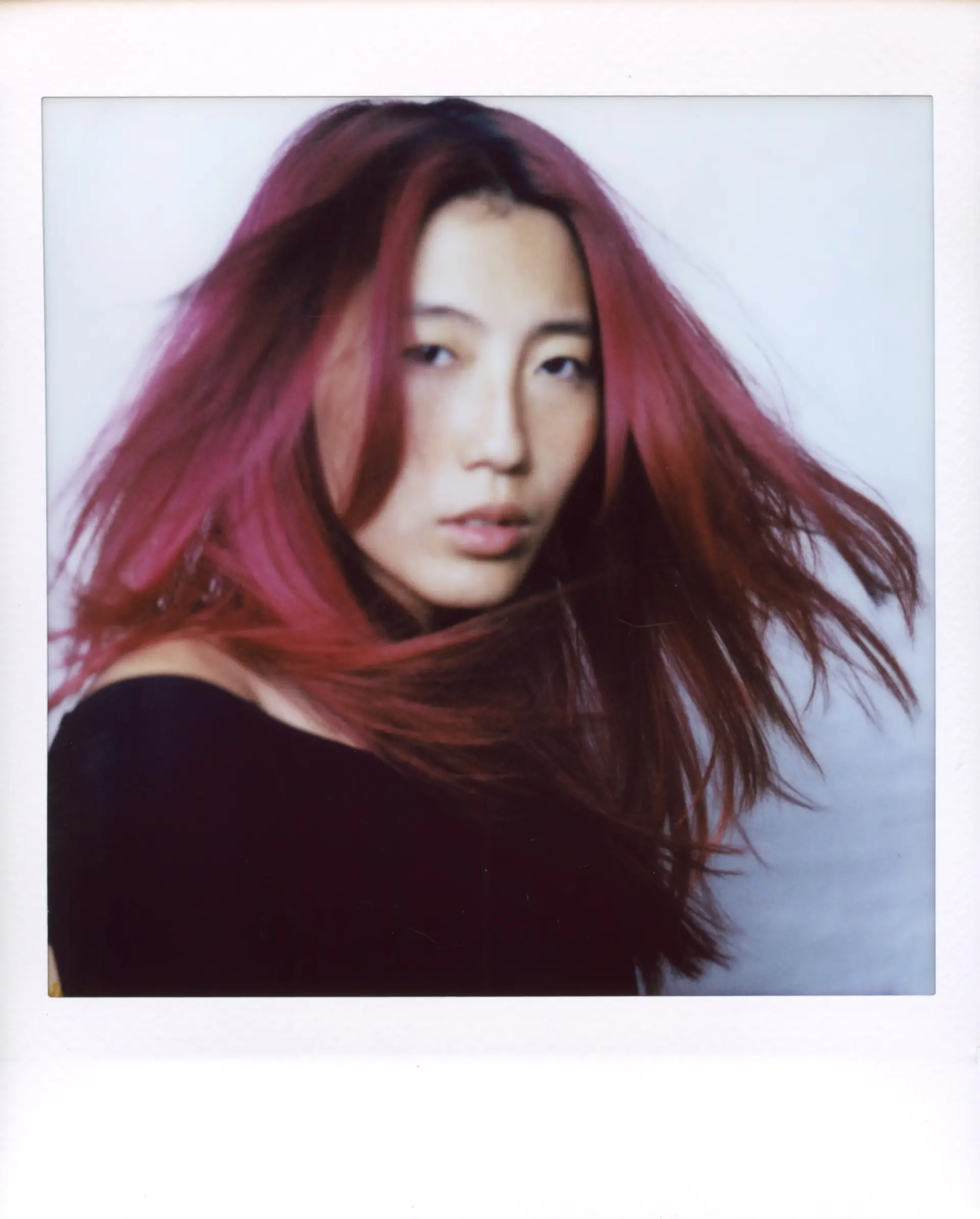 Vivid magenta-pink long hair with dark roots and face-framing layers styled with windblown texture. 1