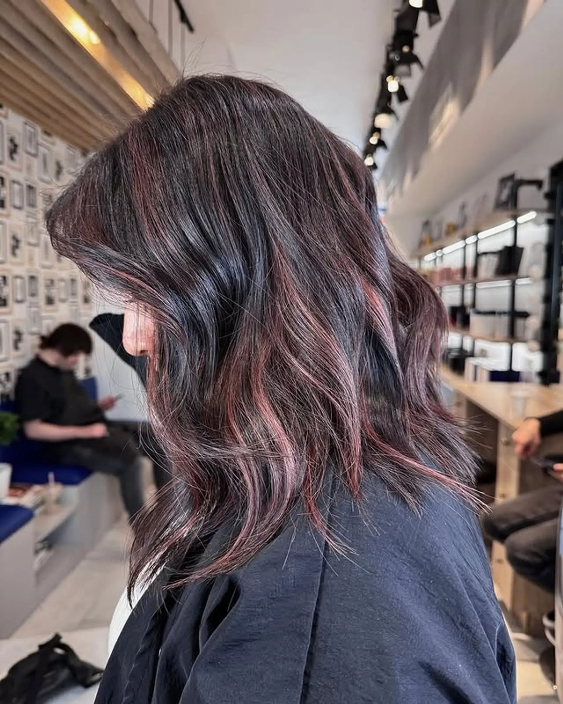 A stylish medium-length wavy lob with striking burgundy highlights. 1