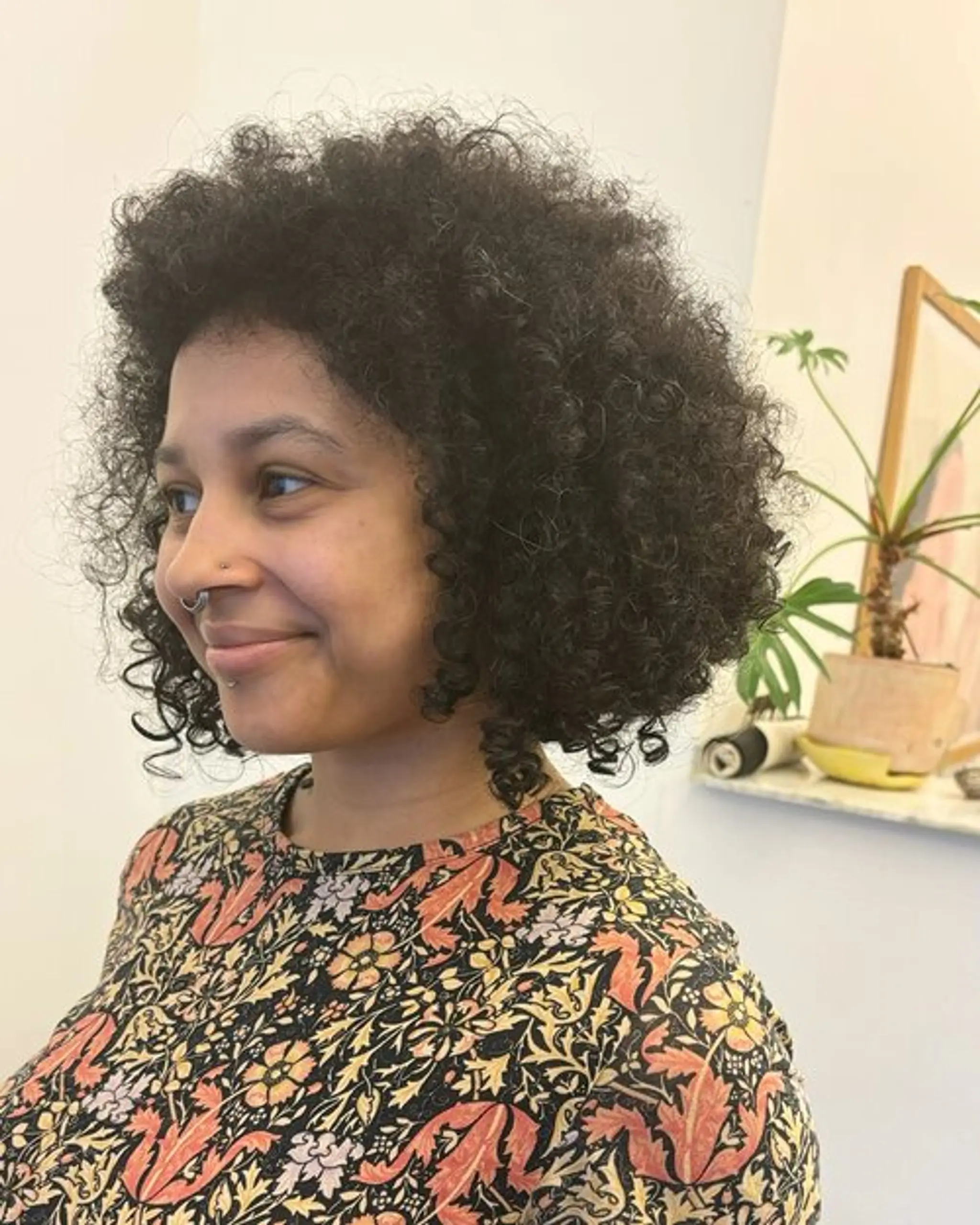 Naturally curly hair in a voluminous, layered bob that falls just above the shoulders, with a rich black color enhancing the shine. Haircut by @takeohair
