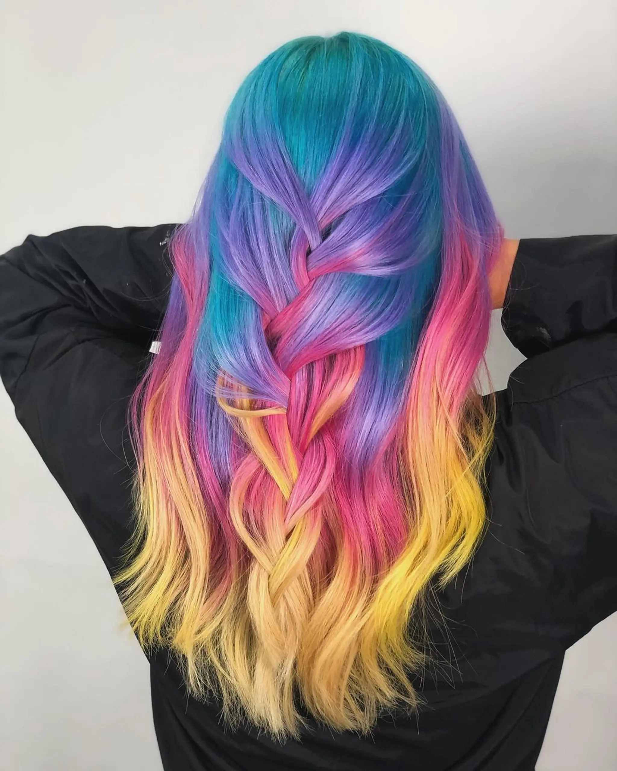 Long, straight hair styled in a loose braid with vibrant colors transitioning in a gradient from blue to purple, pink, yellow, and blonde.
Stylist - @xcellent_jason