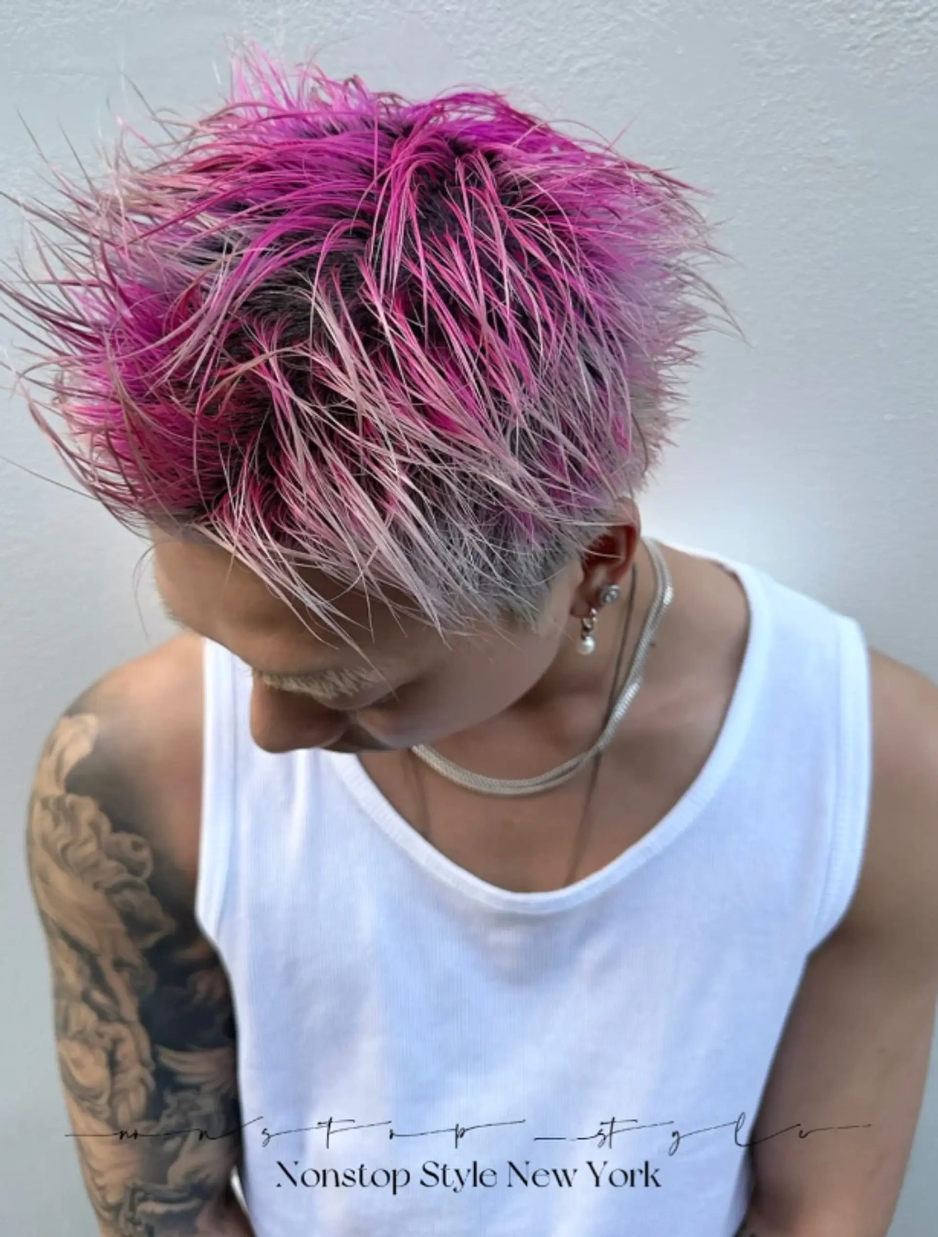 A short pixie cut with an undercut, featuring spiky, textured layers in vivid pink and platinum blonde. 2
