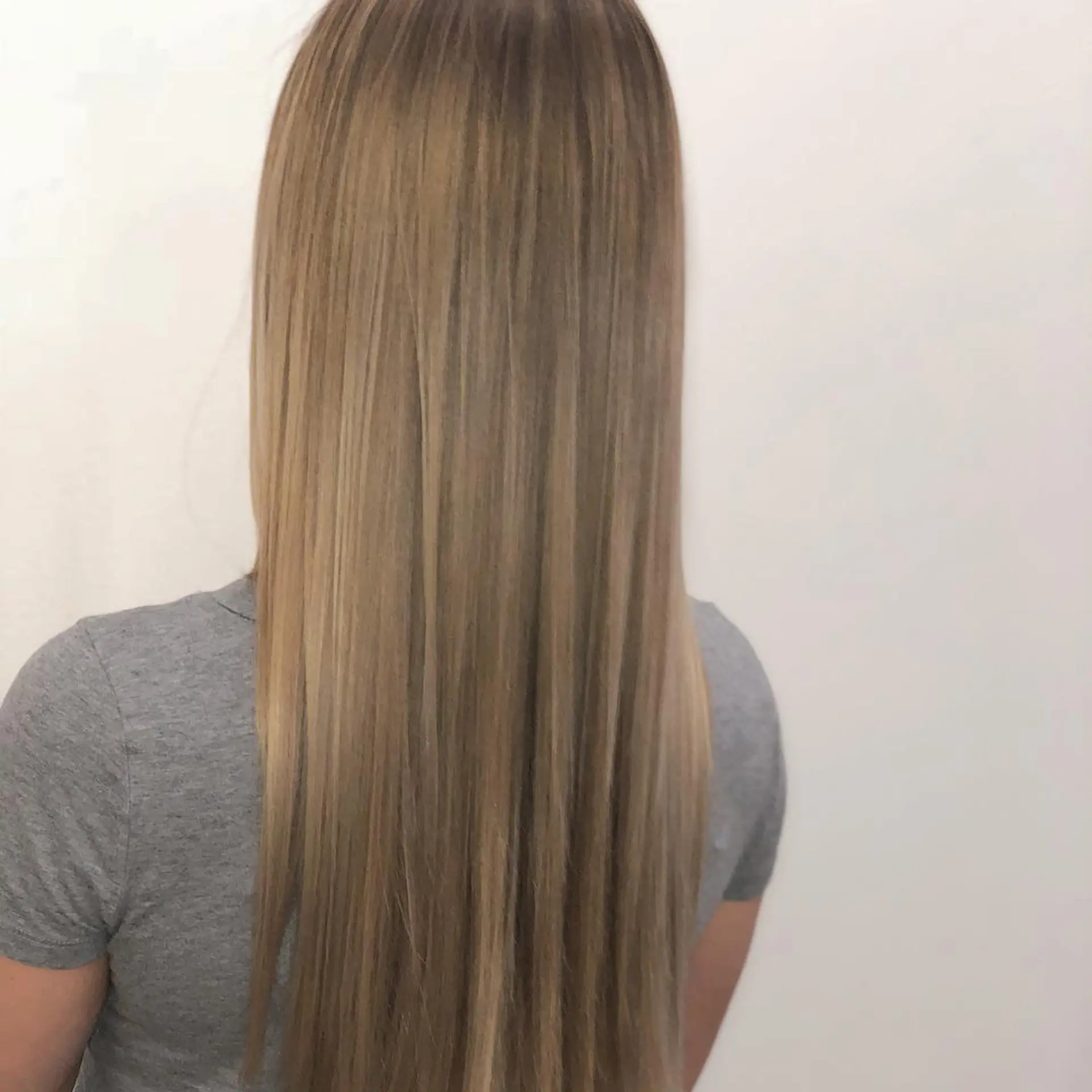 Straight, long hair painted with soft beige blonde tones and blended with a subtle root shadow. 1