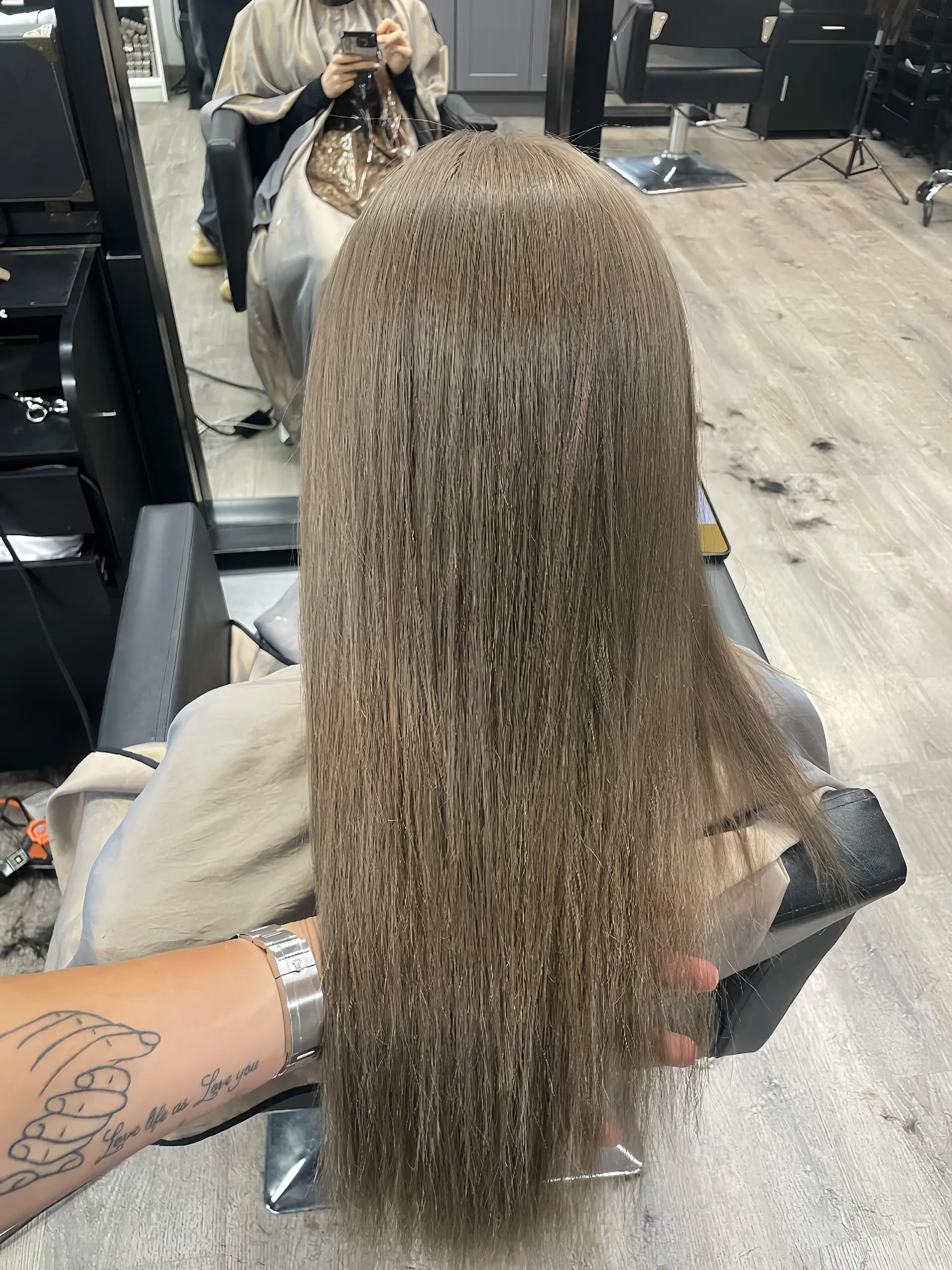 A sleek and straight long hairstyle with a modern ash blonde color. 1