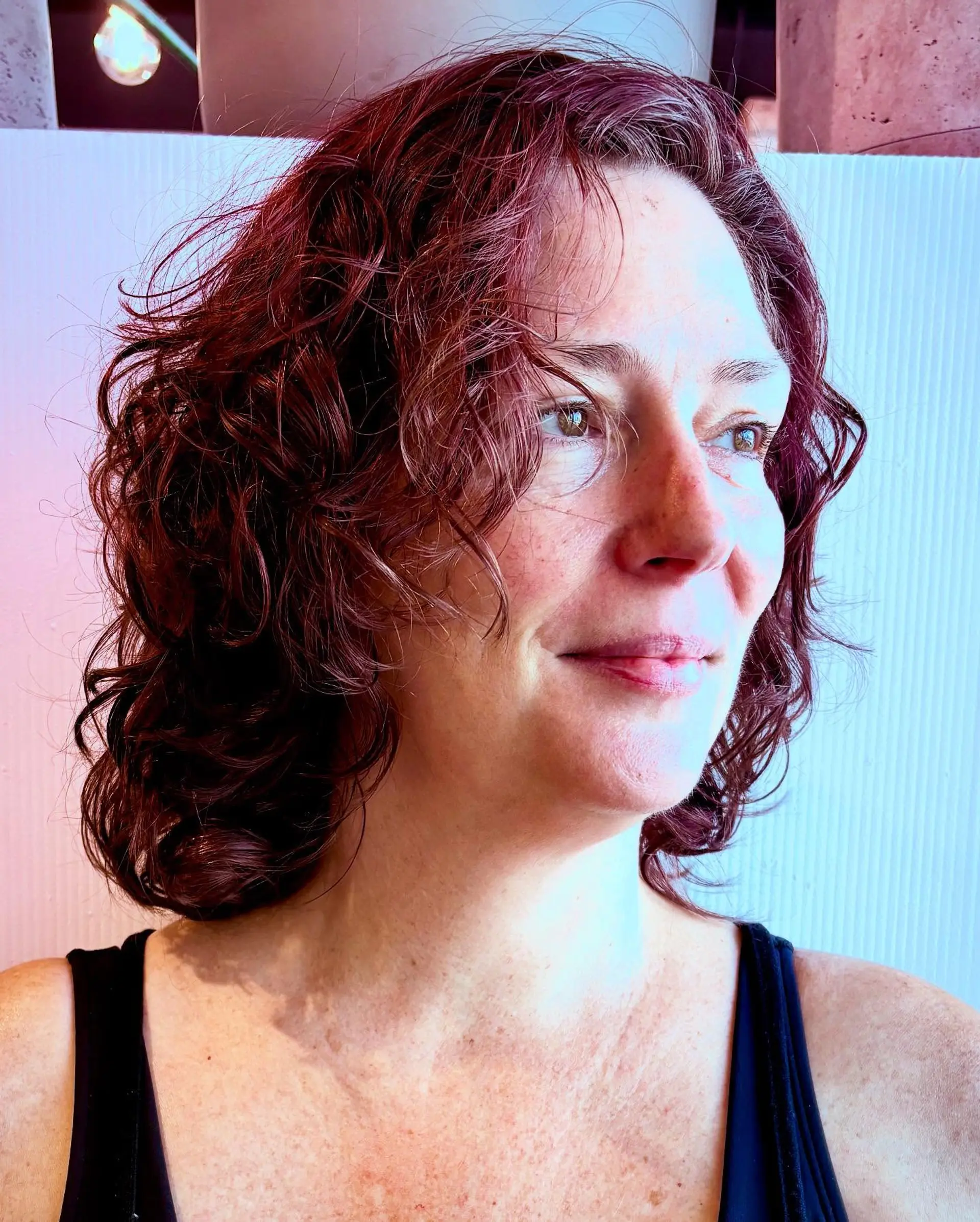 A medium-length, reshaped curly cut featuring soft layers and natural curl definition in a rich auburn tone. 1