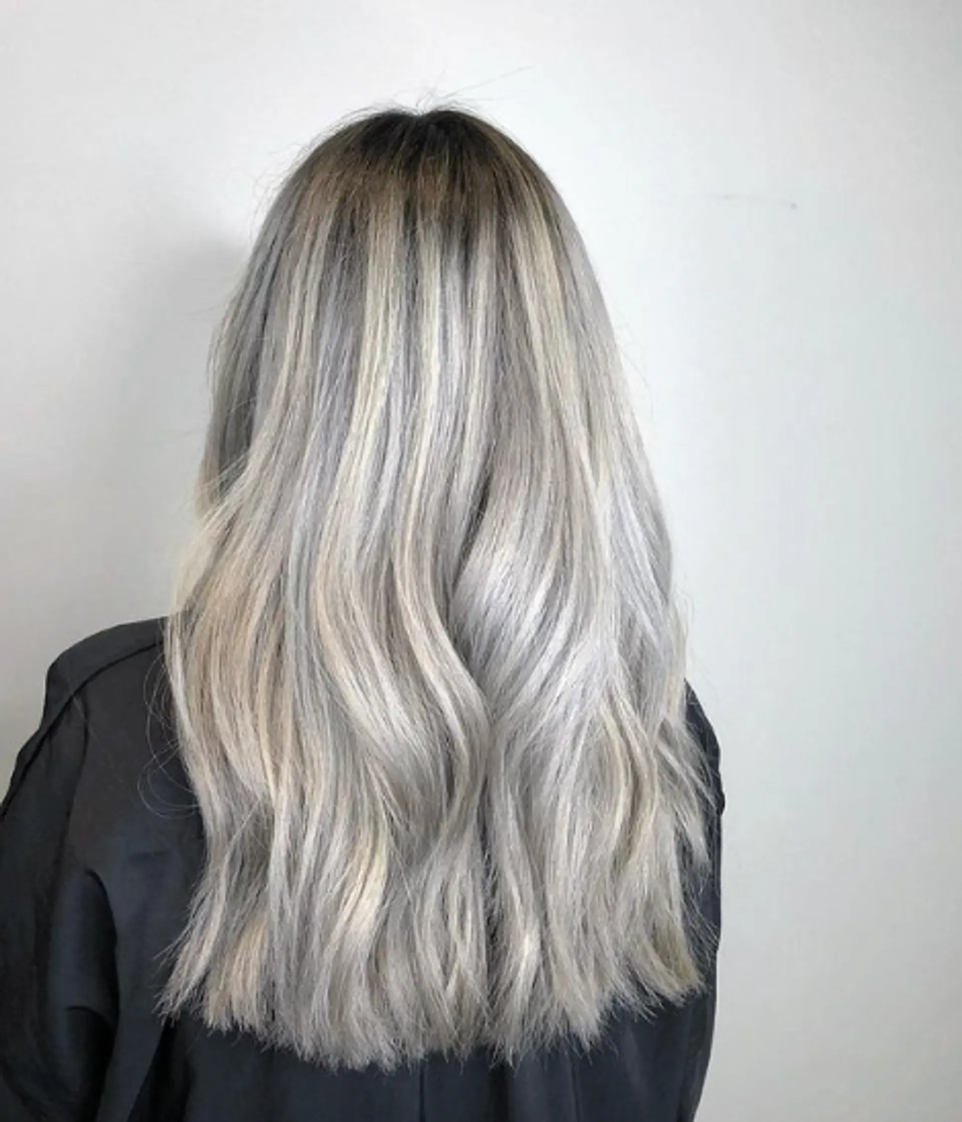 Long, wavy hair with a silver and grey ombre effect, transitioning to ash blonde tips. Layered, voluminous cut with a silky, flowing texture and subtle waves. 1