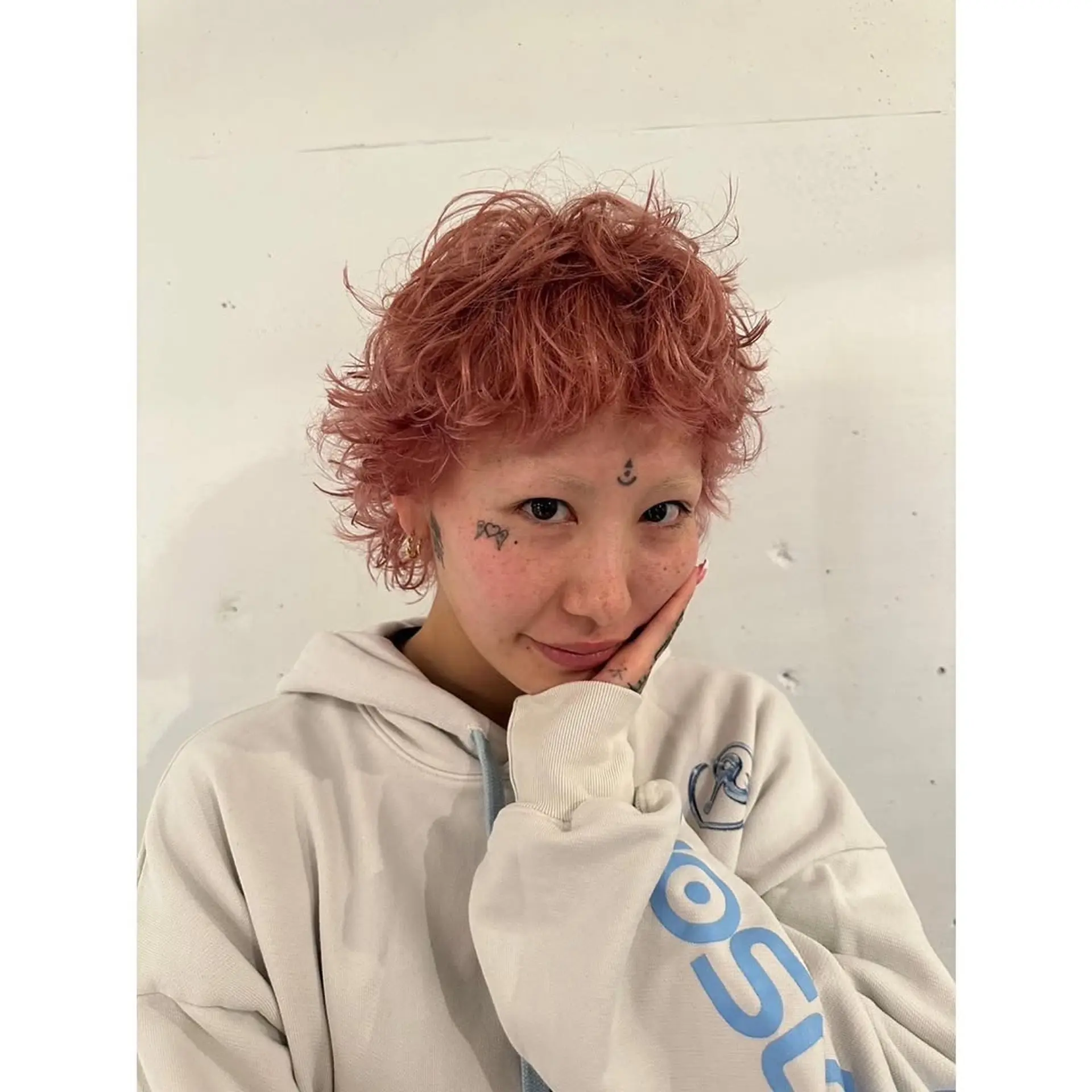 A short, textured pixie cut with a curly texture. 1