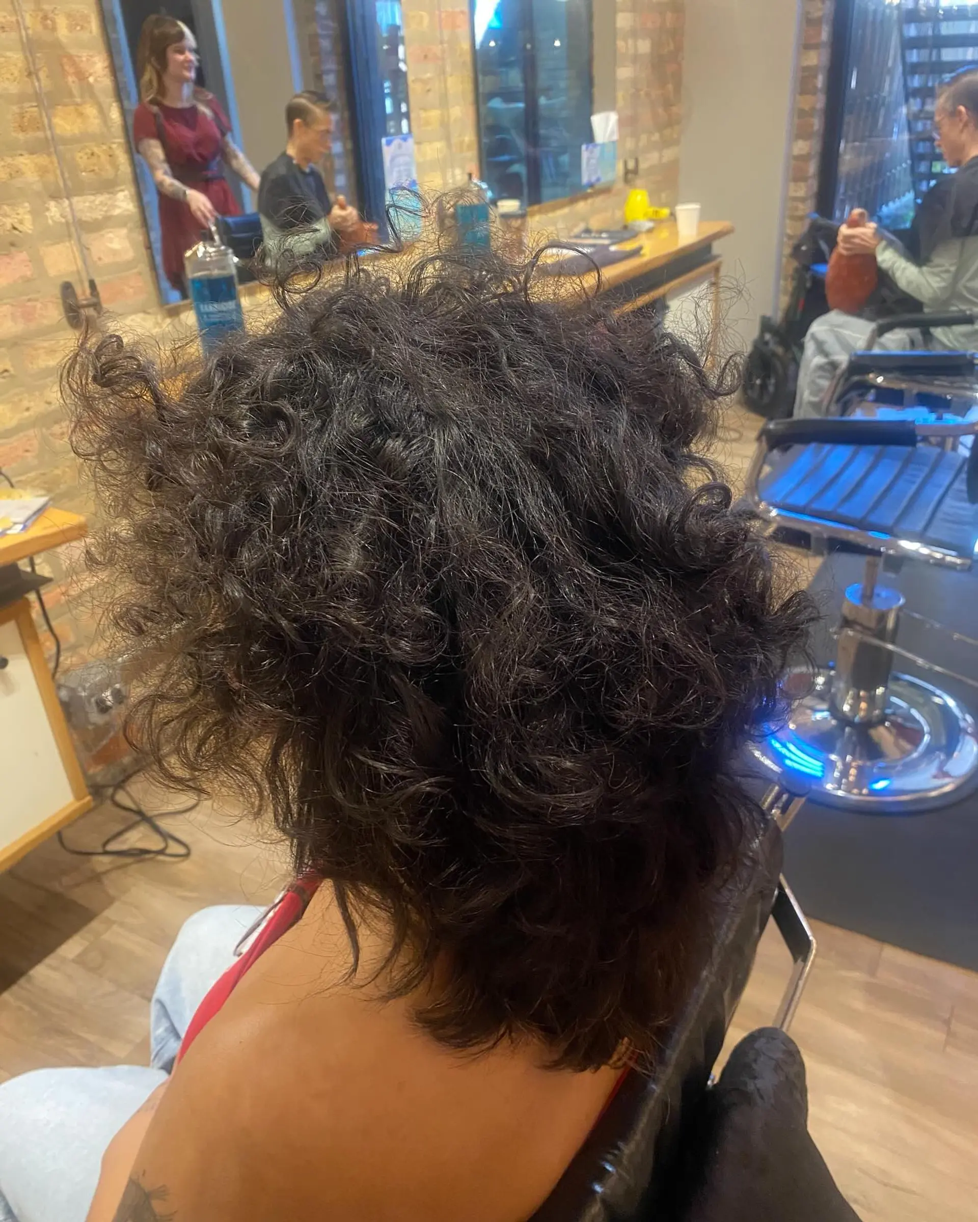 A shaggy, curly hairstyle with a trendy color contrast, with blonde highlights on black hair. 2